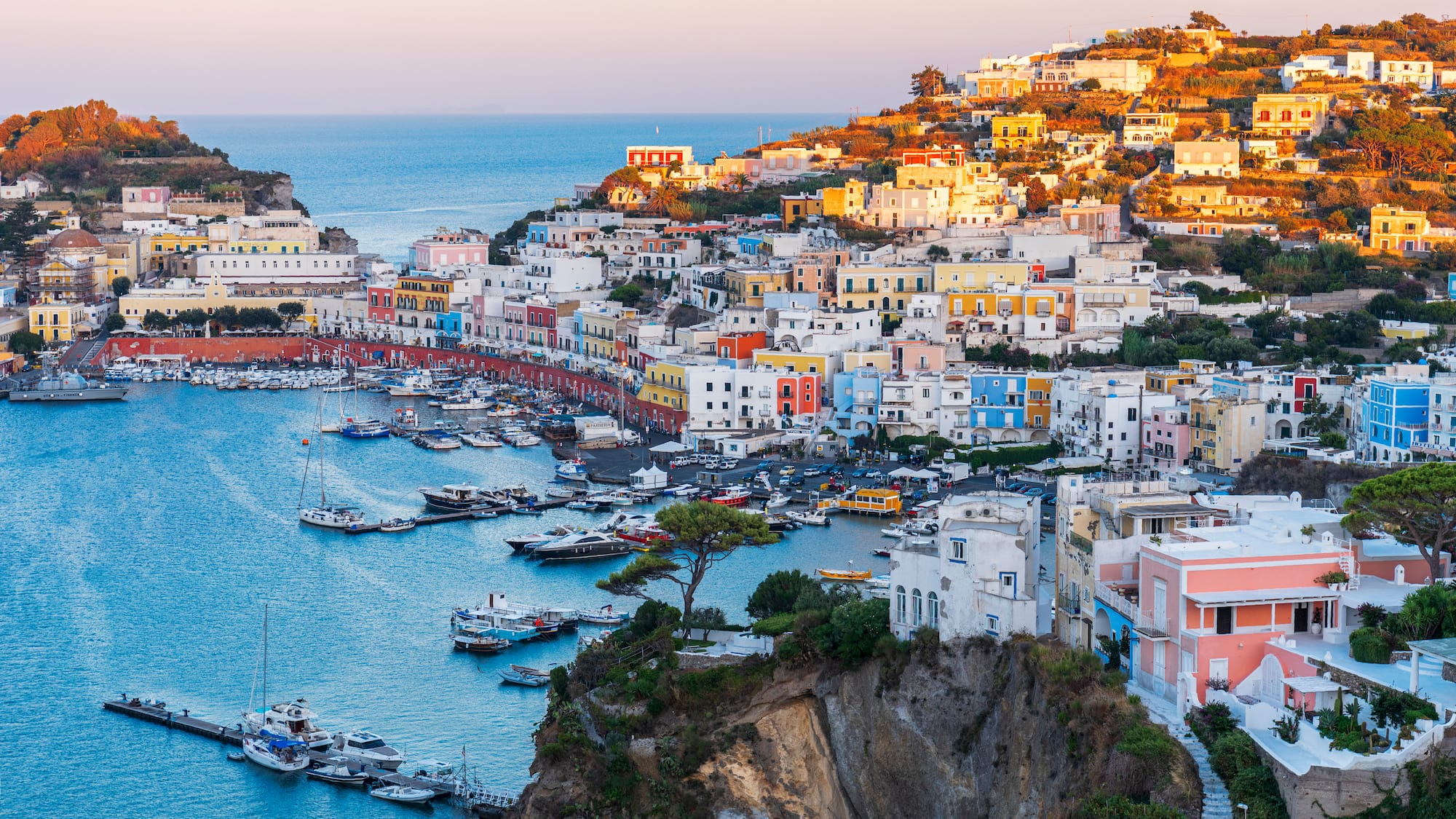 a city on a hill with boats on the water