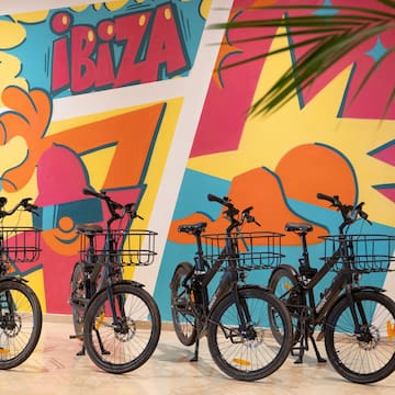 a group of bicycles with baskets in front of a colorful wall