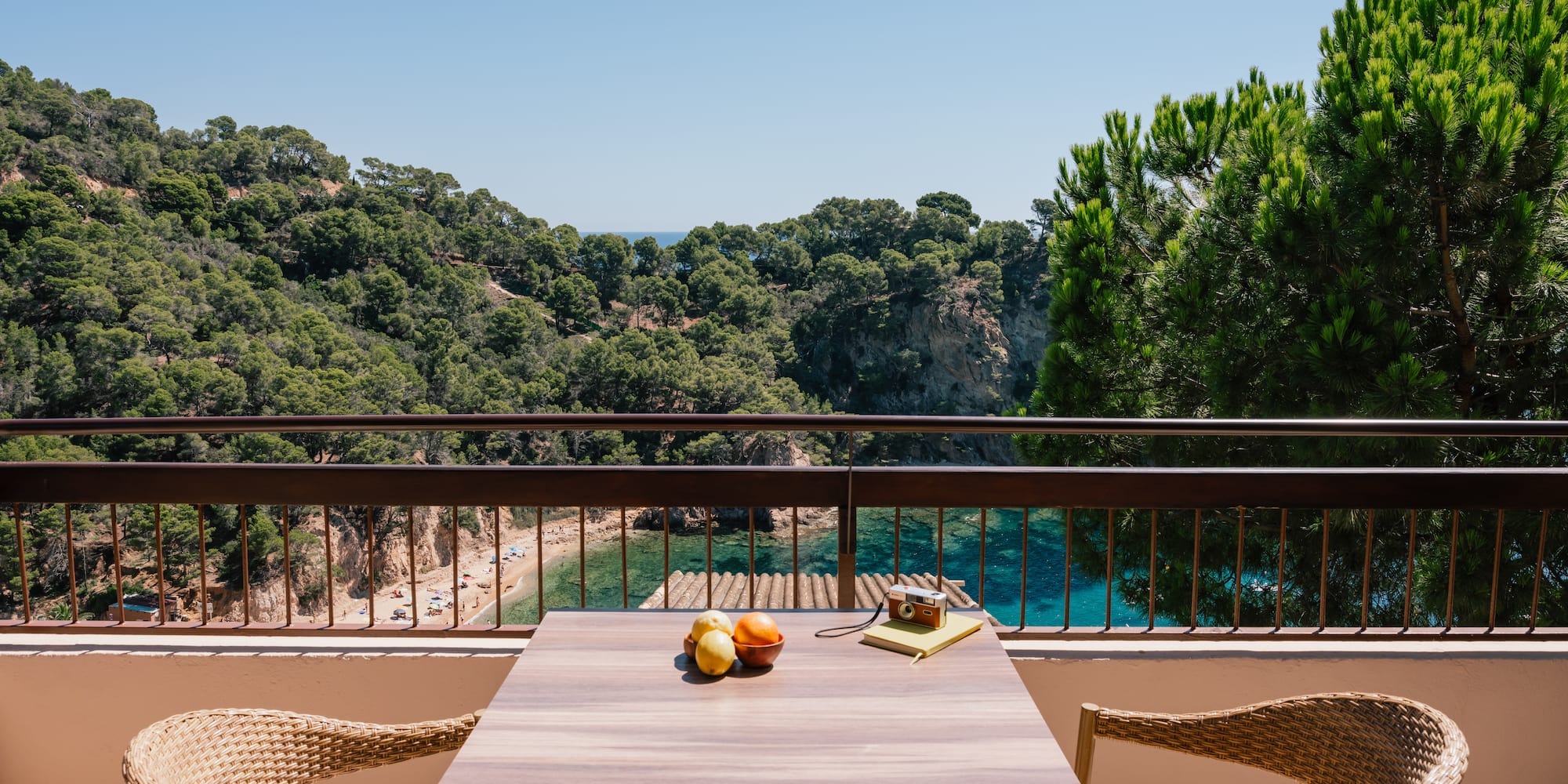 a table and chairs on a balcony overlooking a body of water