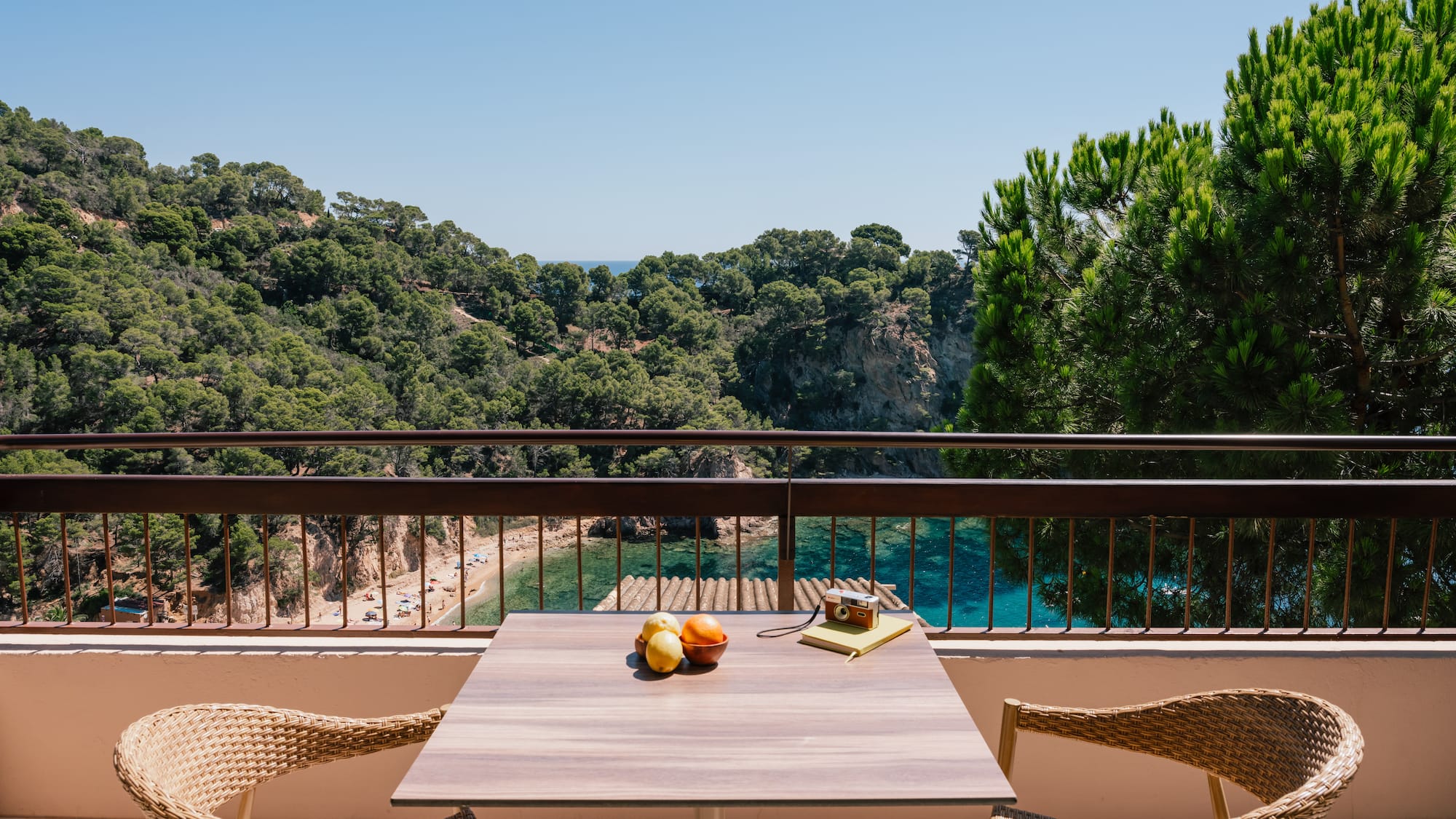 a table and chairs on a balcony overlooking a body of water