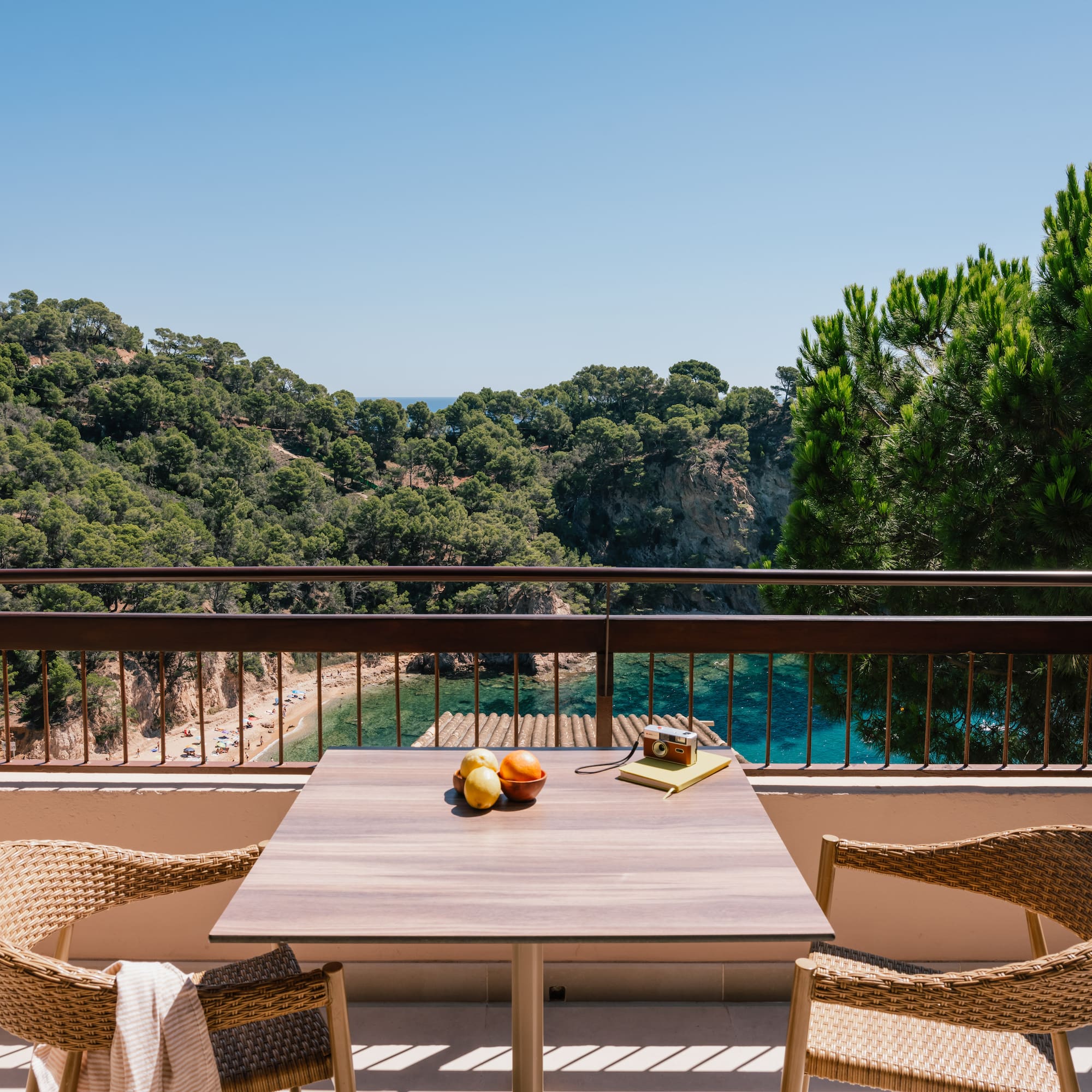 a table and chairs on a balcony overlooking a body of water