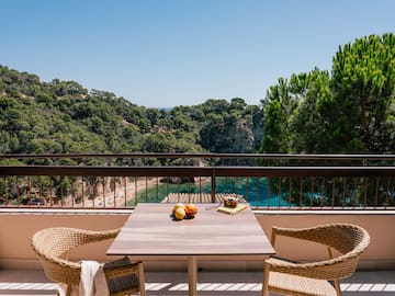 a table and chairs on a balcony overlooking a body of water