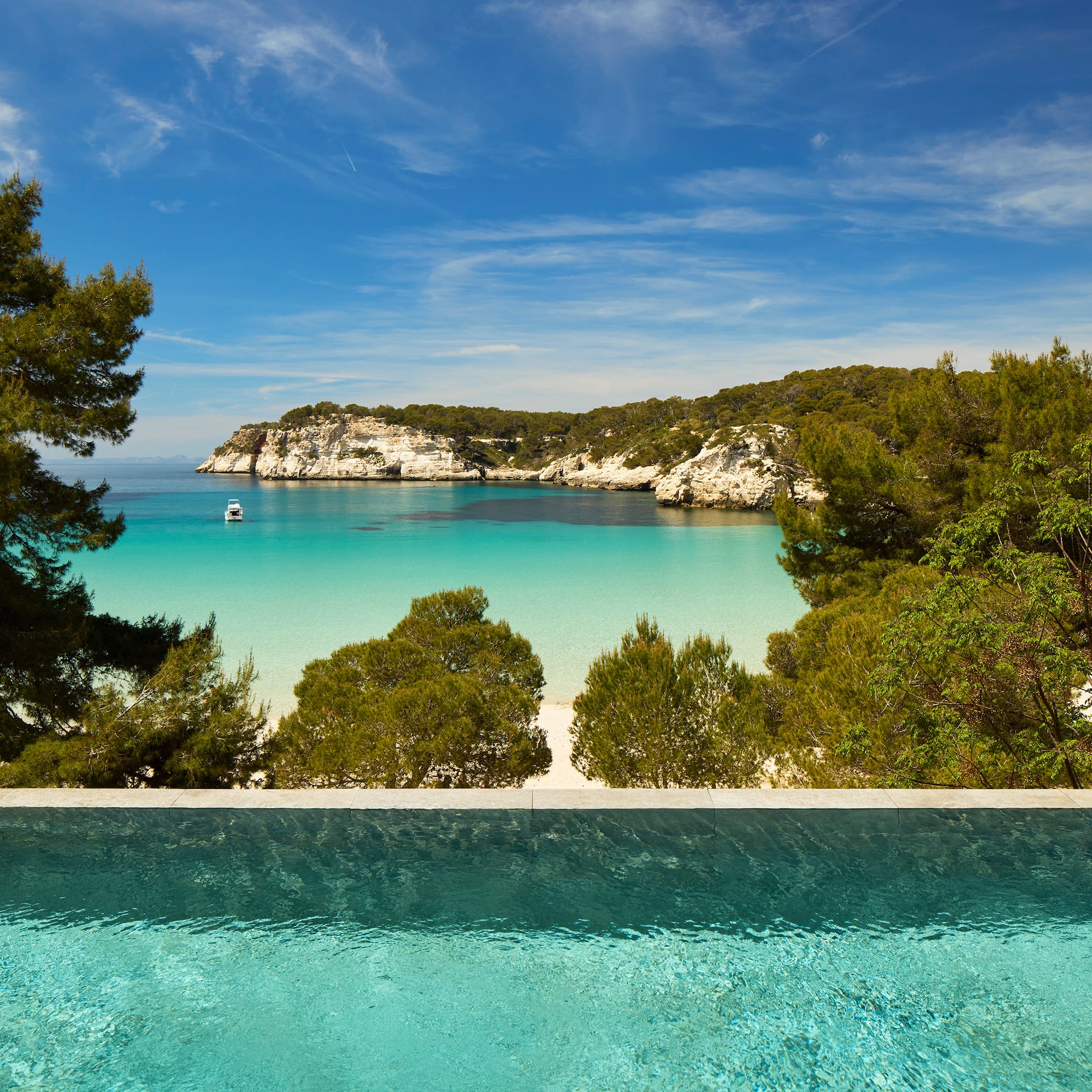a pool overlooking a beach and trees
