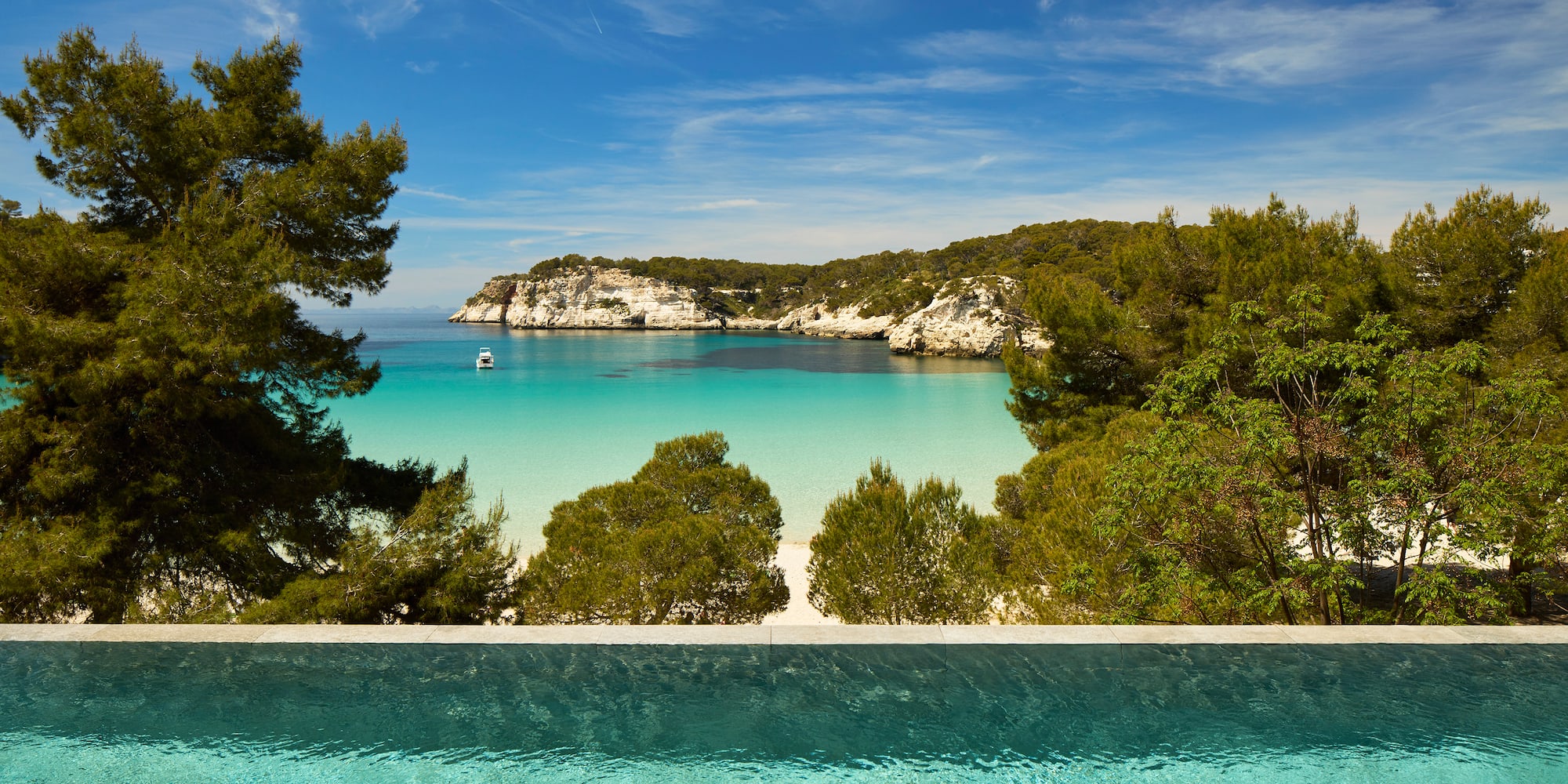 a pool overlooking a beach and trees