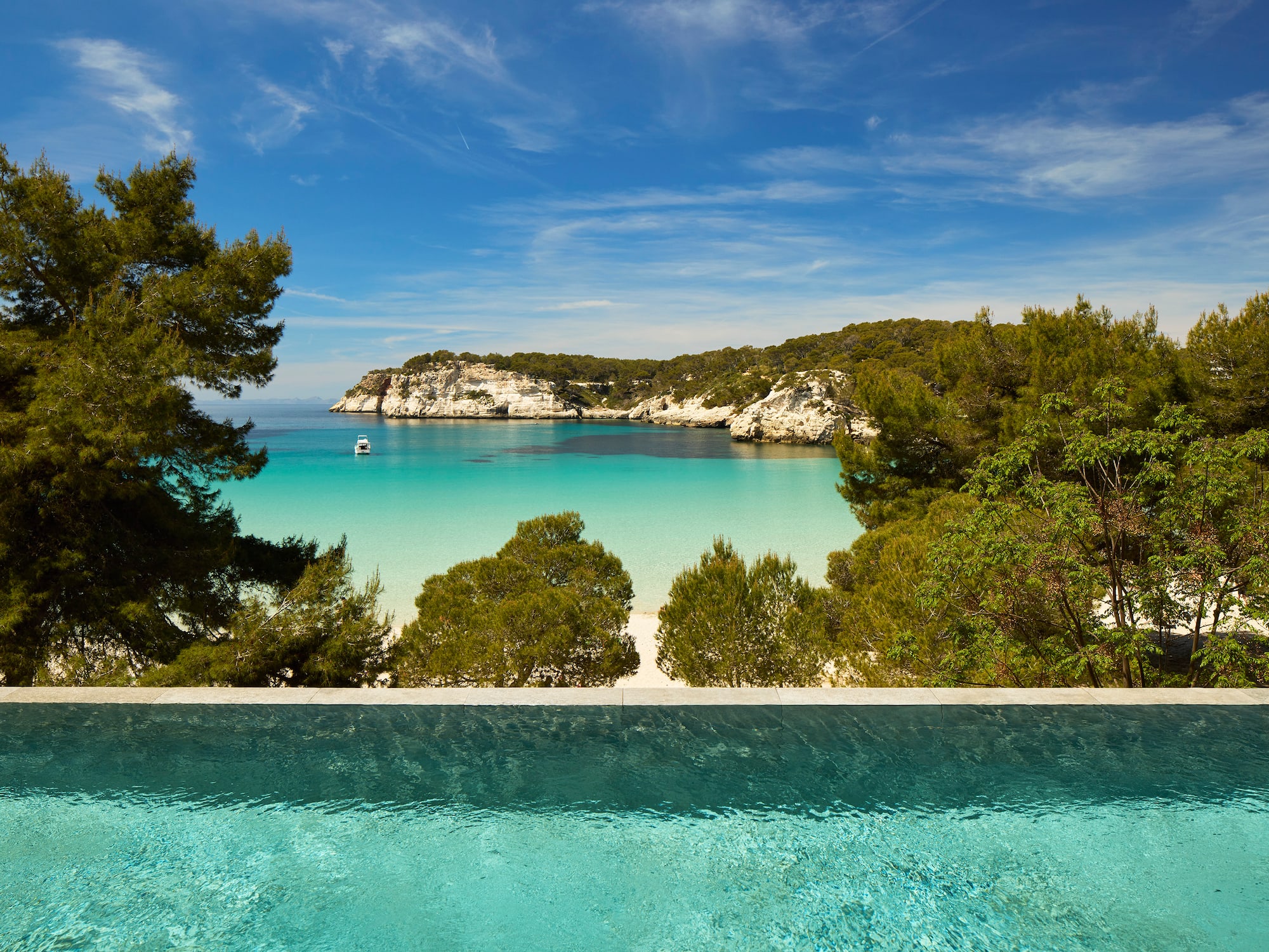 a pool overlooking a beach and trees