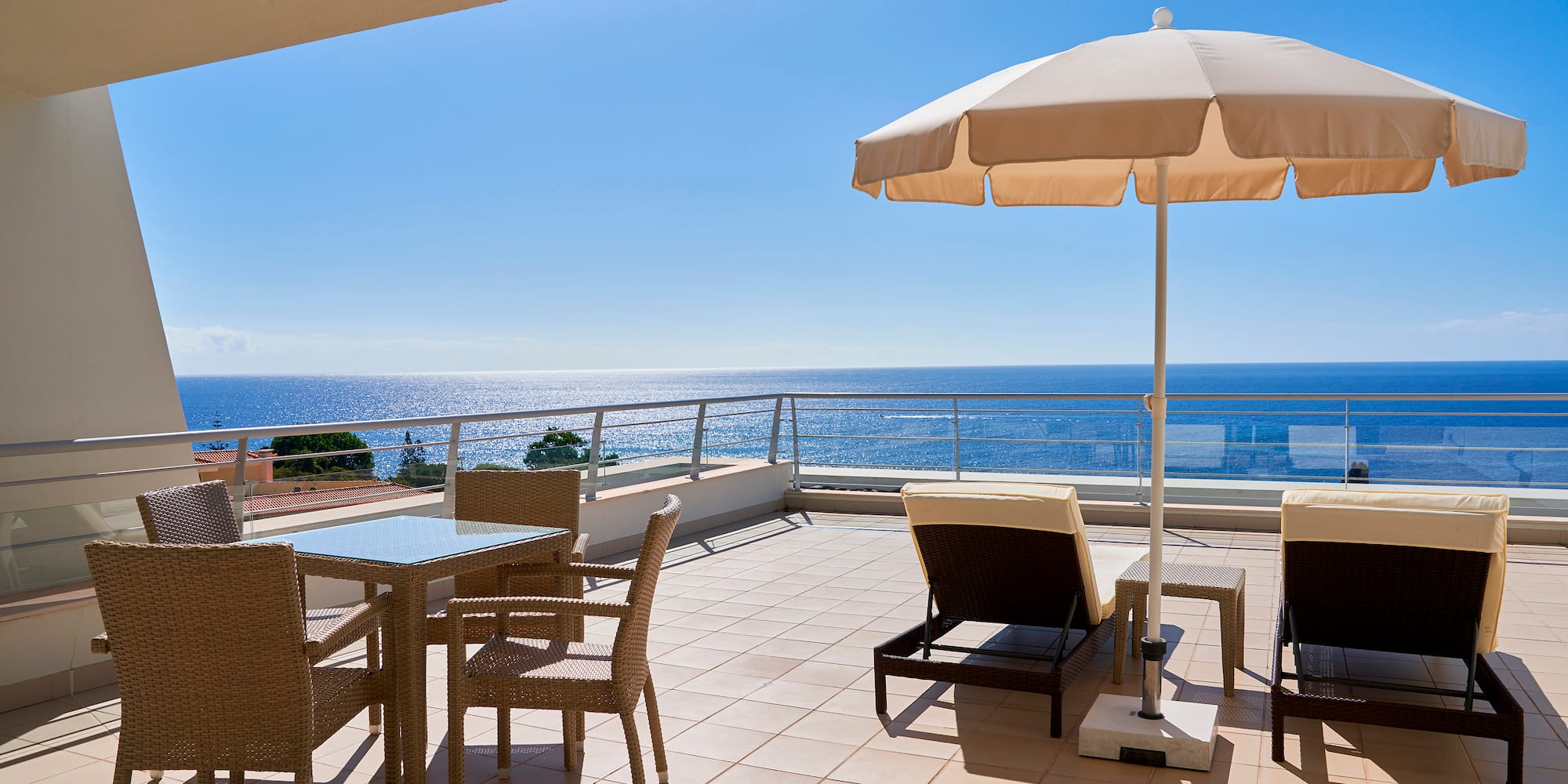 a patio with chairs and umbrella on a sunny day