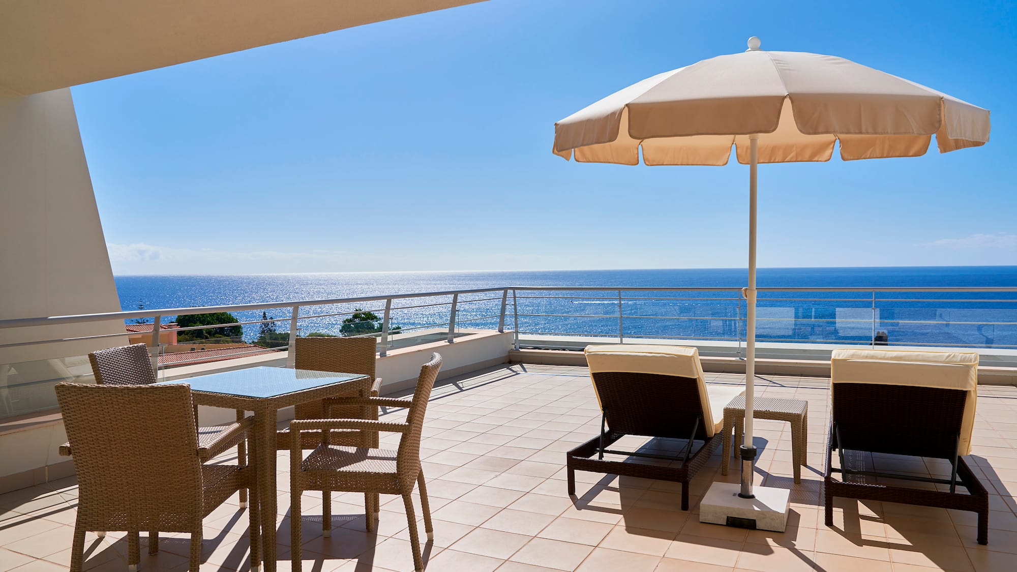 a patio with chairs and umbrella on a sunny day