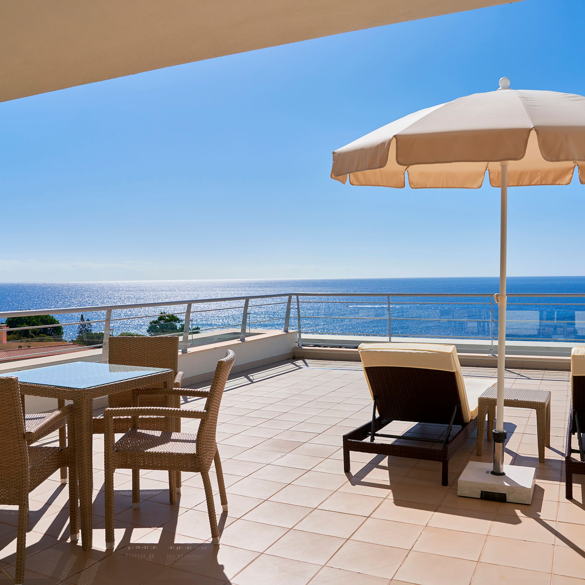 a patio with chairs and umbrella on a sunny day