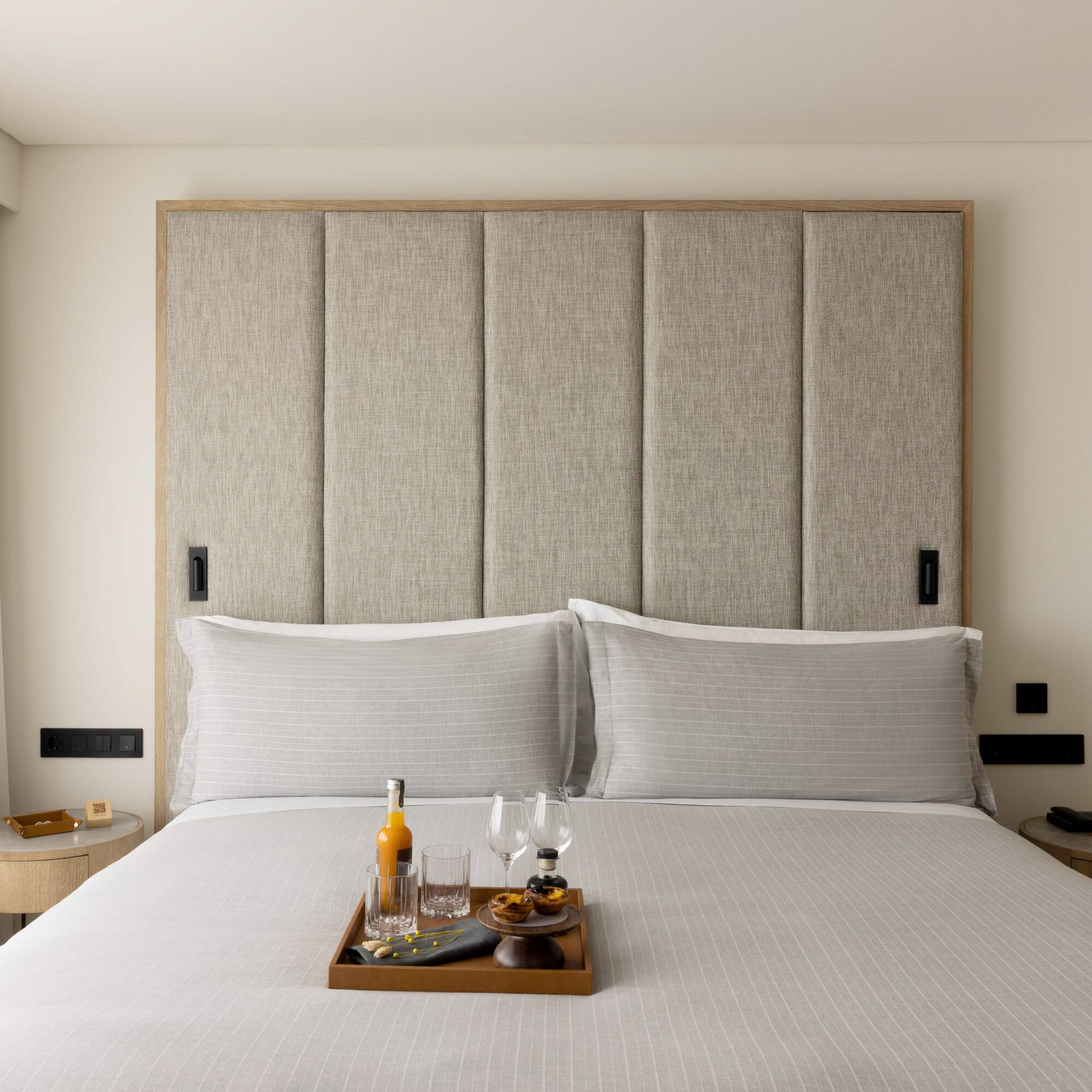 a tray of wine glasses and glasses on a bed