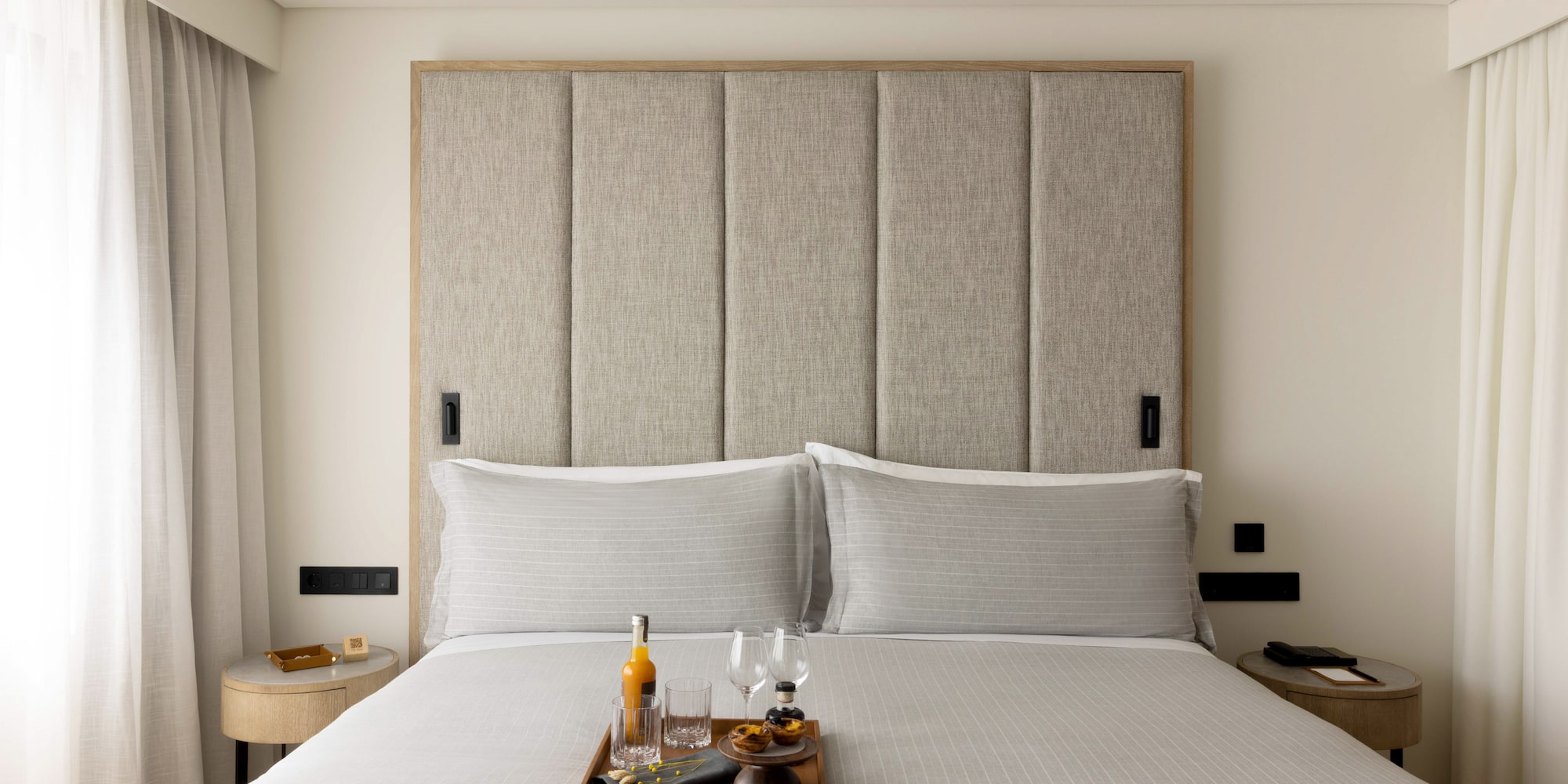 a tray of wine glasses and glasses on a bed