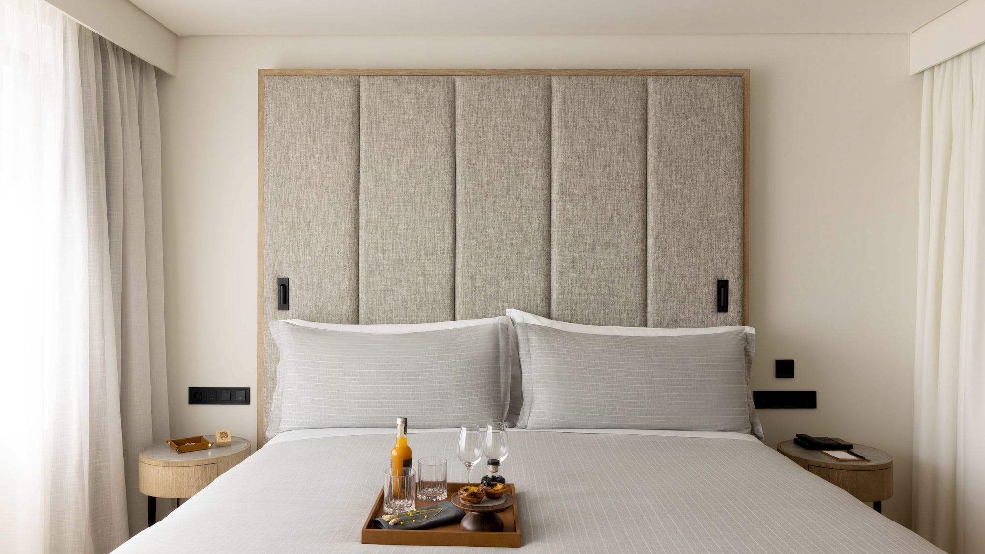 a tray of wine glasses and glasses on a bed