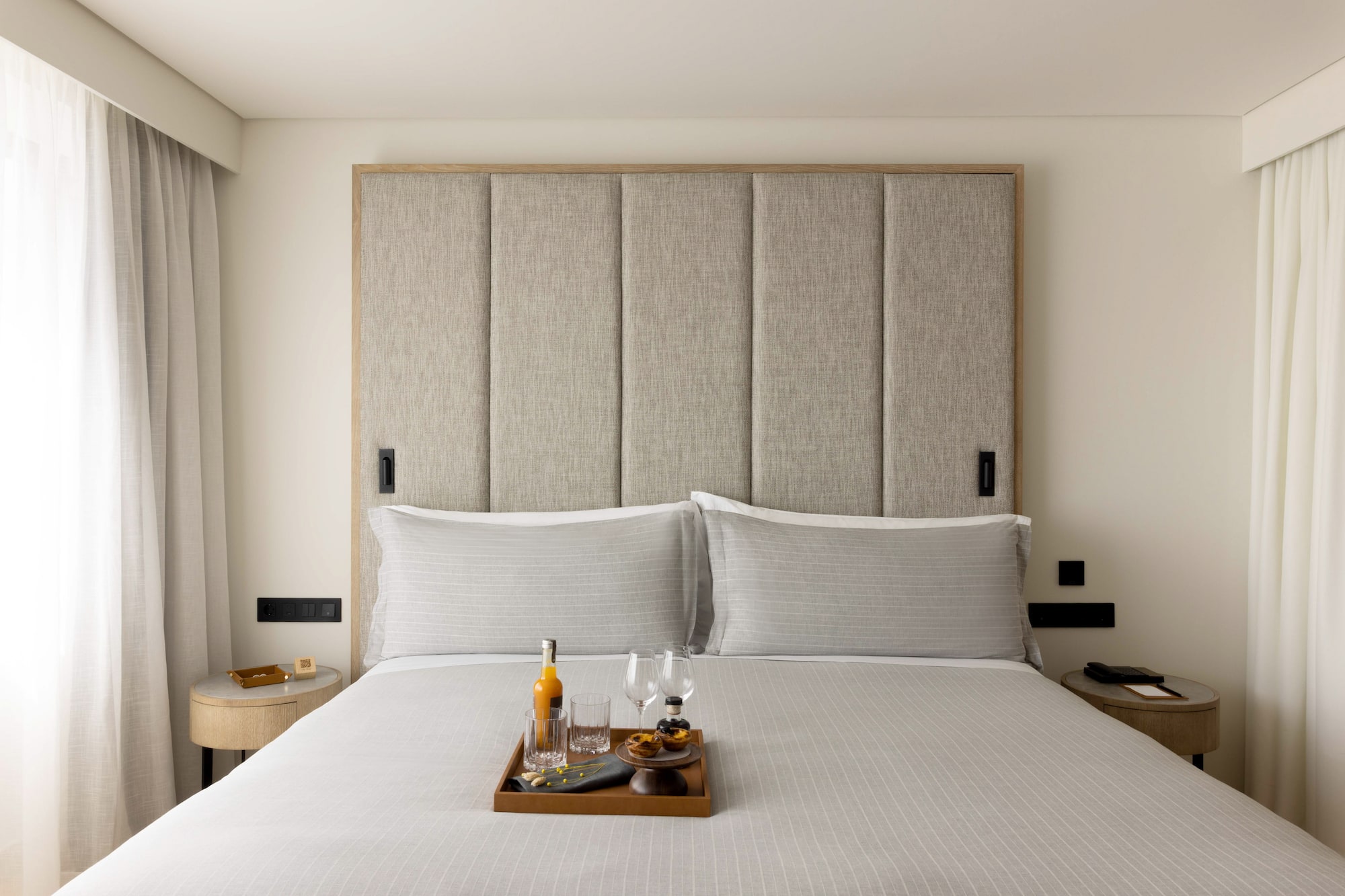 a tray of wine glasses and glasses on a bed