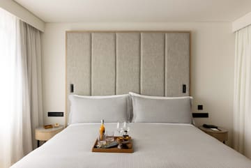 a tray of wine glasses and glasses on a bed