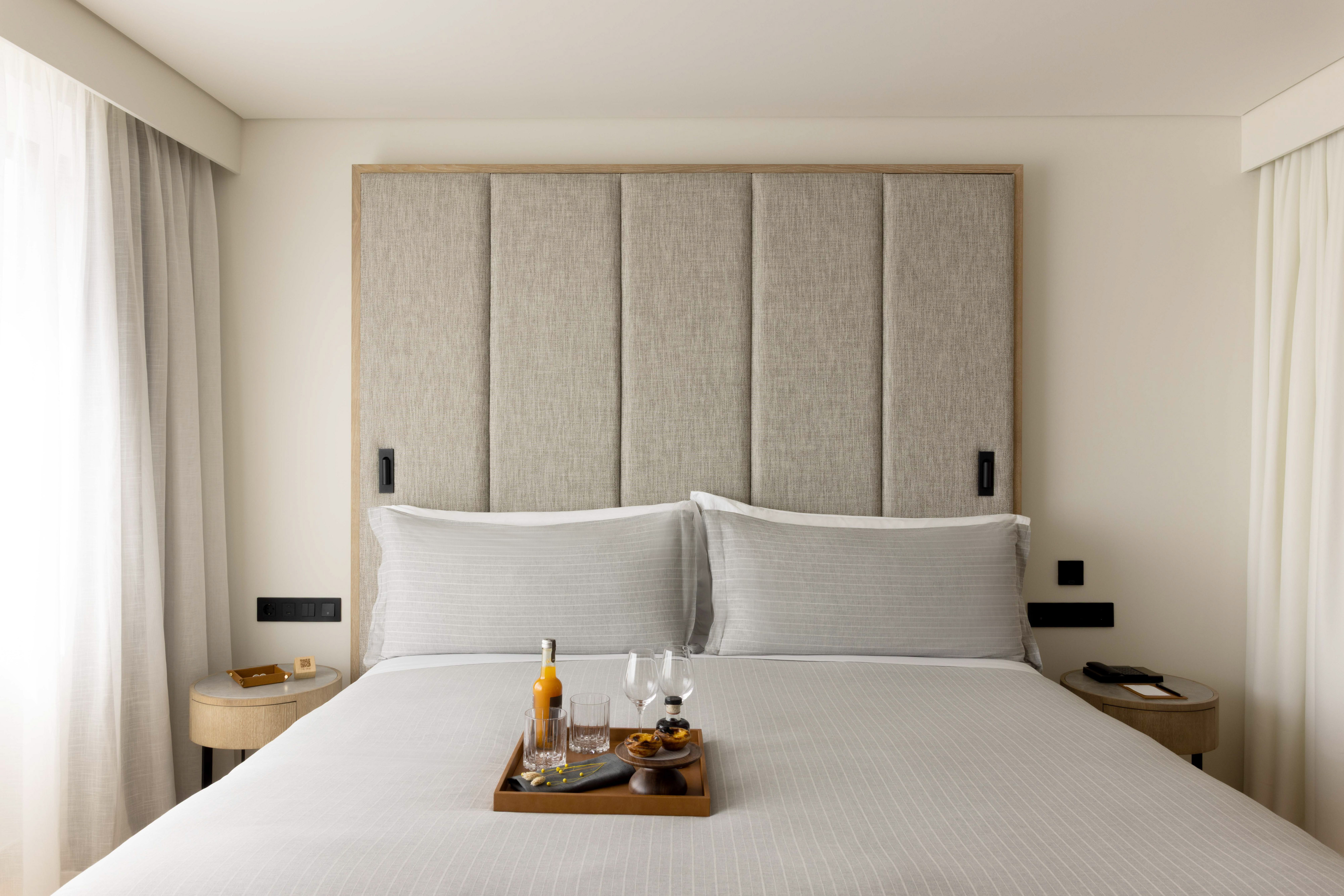 a tray of wine glasses and glasses on a bed