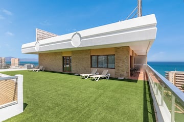 a building with lawn and chairs on the side