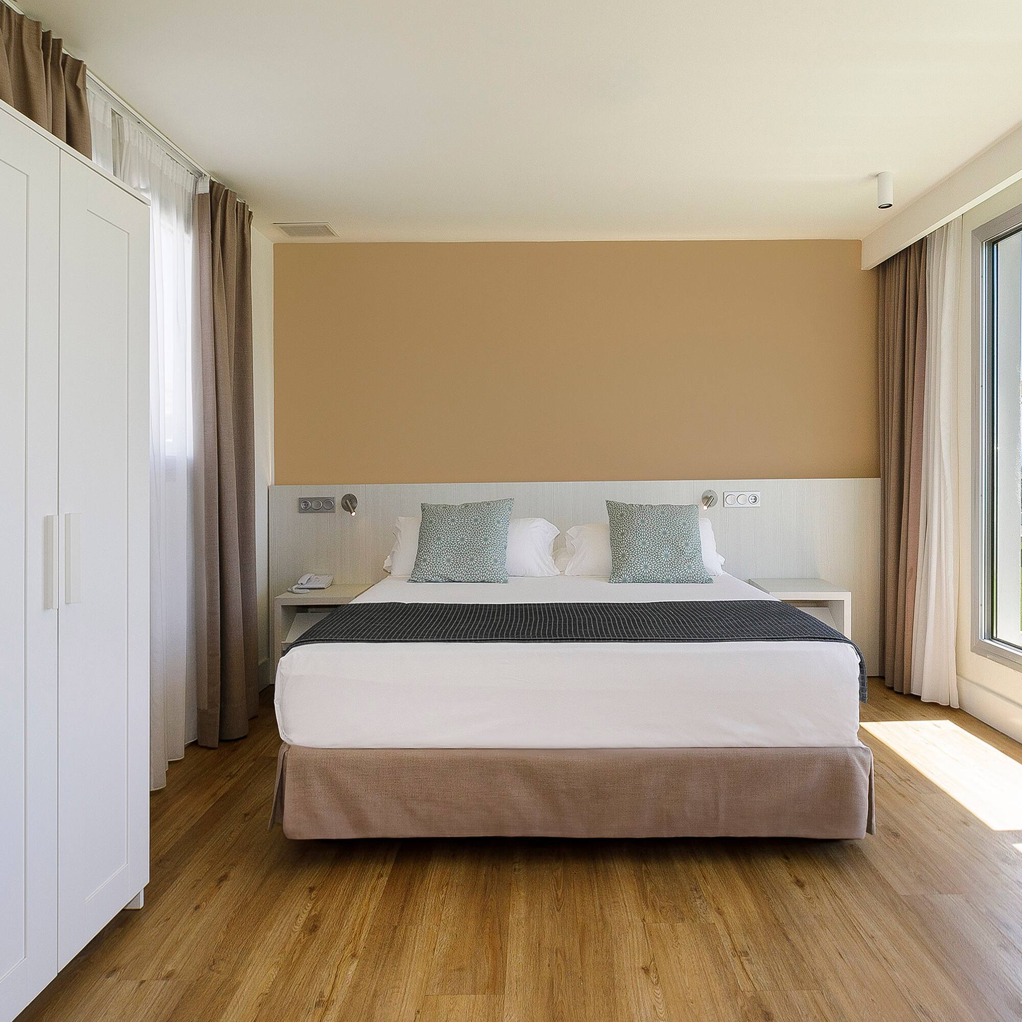 a bedroom with a bed and a large window