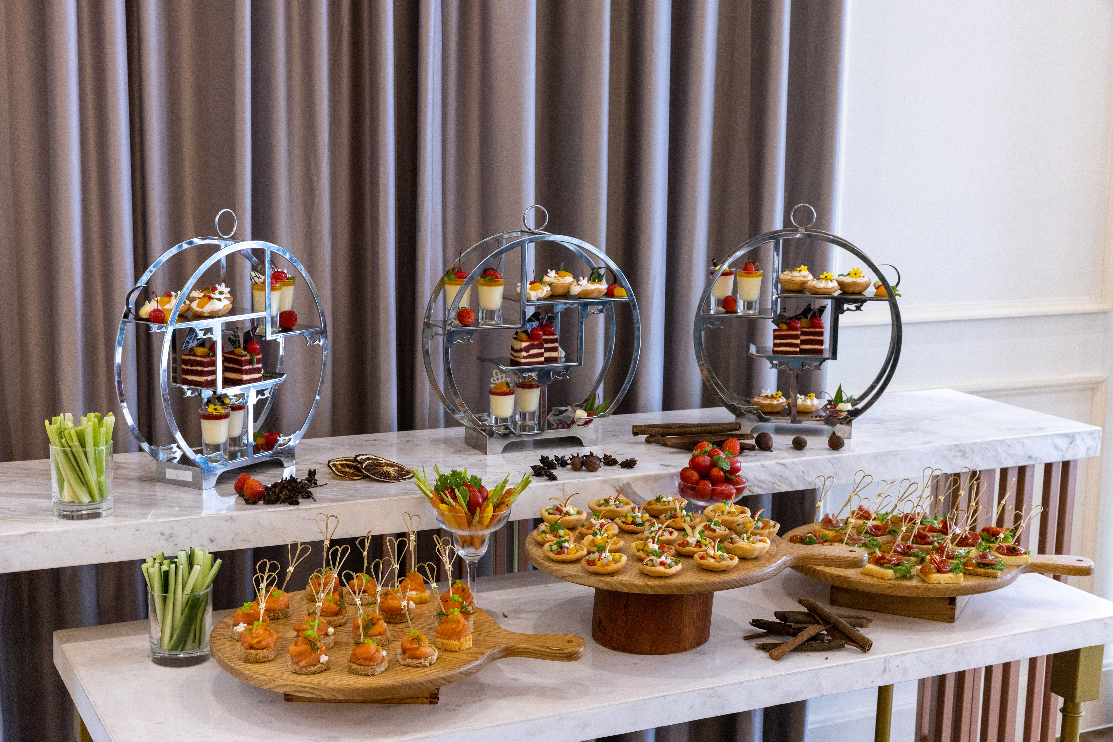 Elegant afternoon tea buffet with mini cakes, tarts, and savory canapés.