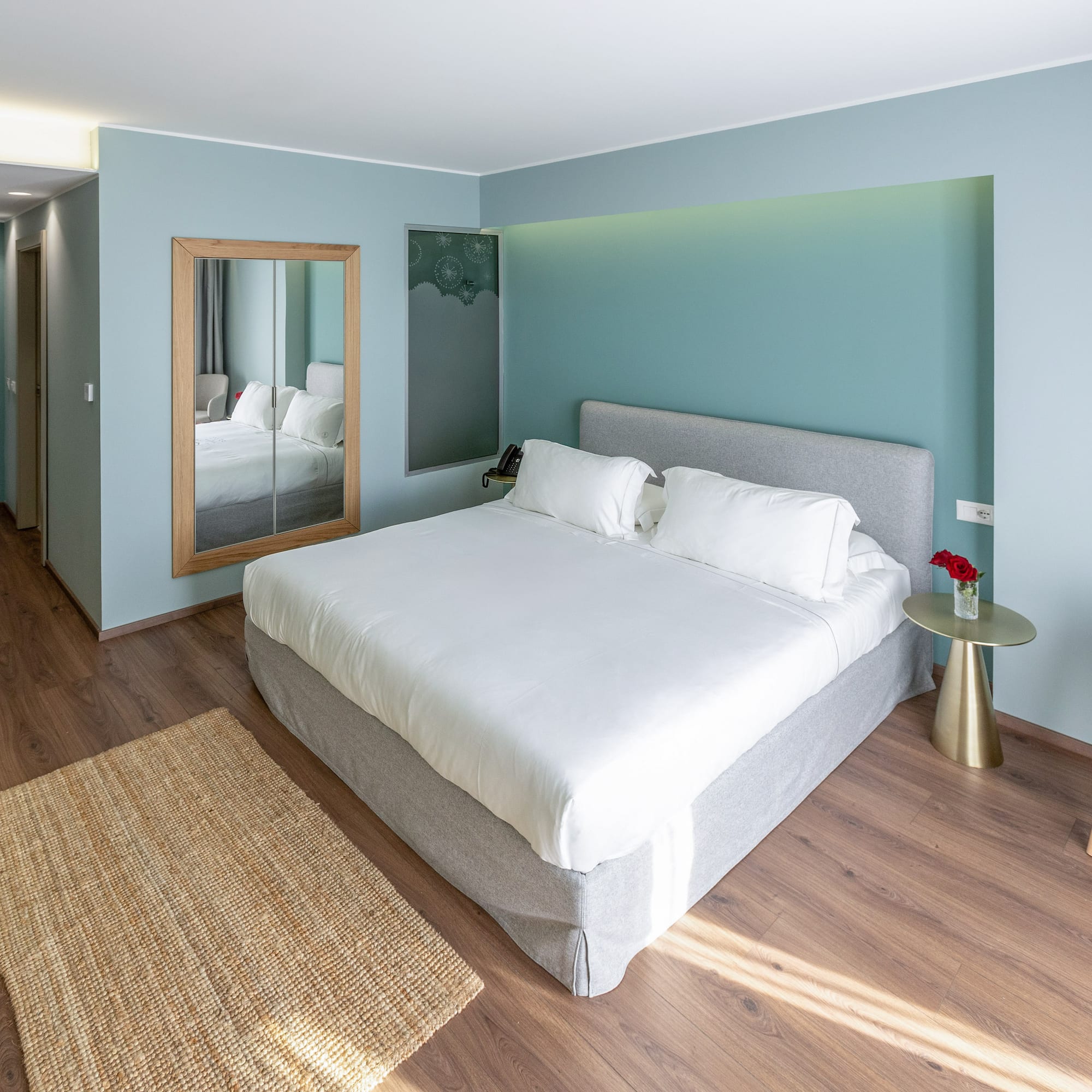 a bedroom with a bed and a mirror