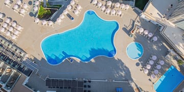 an aerial view of a pool and umbrellas