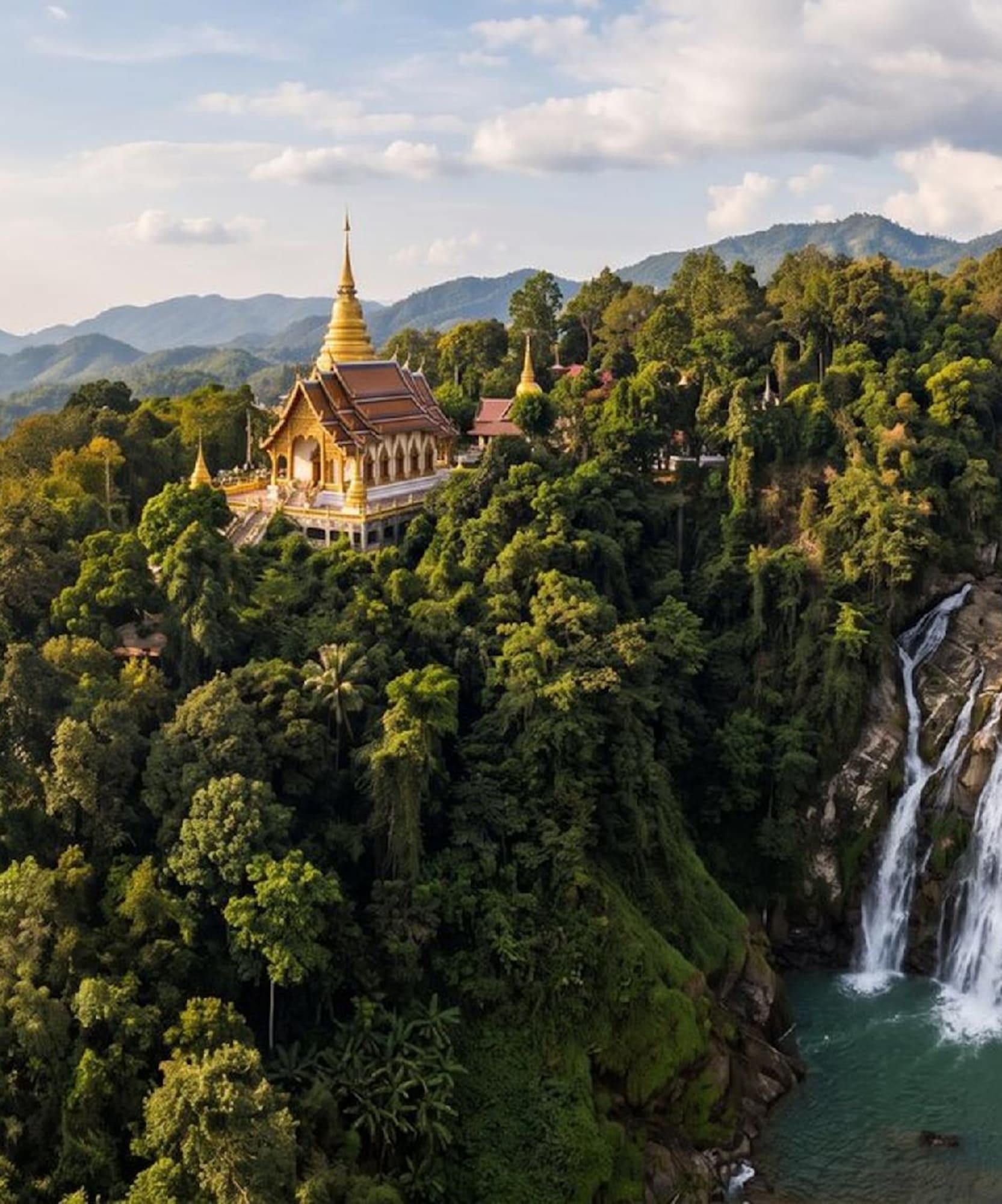 Golden Thai temple on a lush mountain with cascading waterfall.