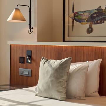 a bed with pillows and a lamp