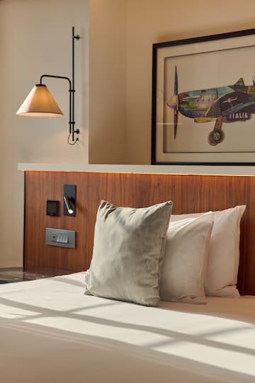 a bed with pillows and a lamp