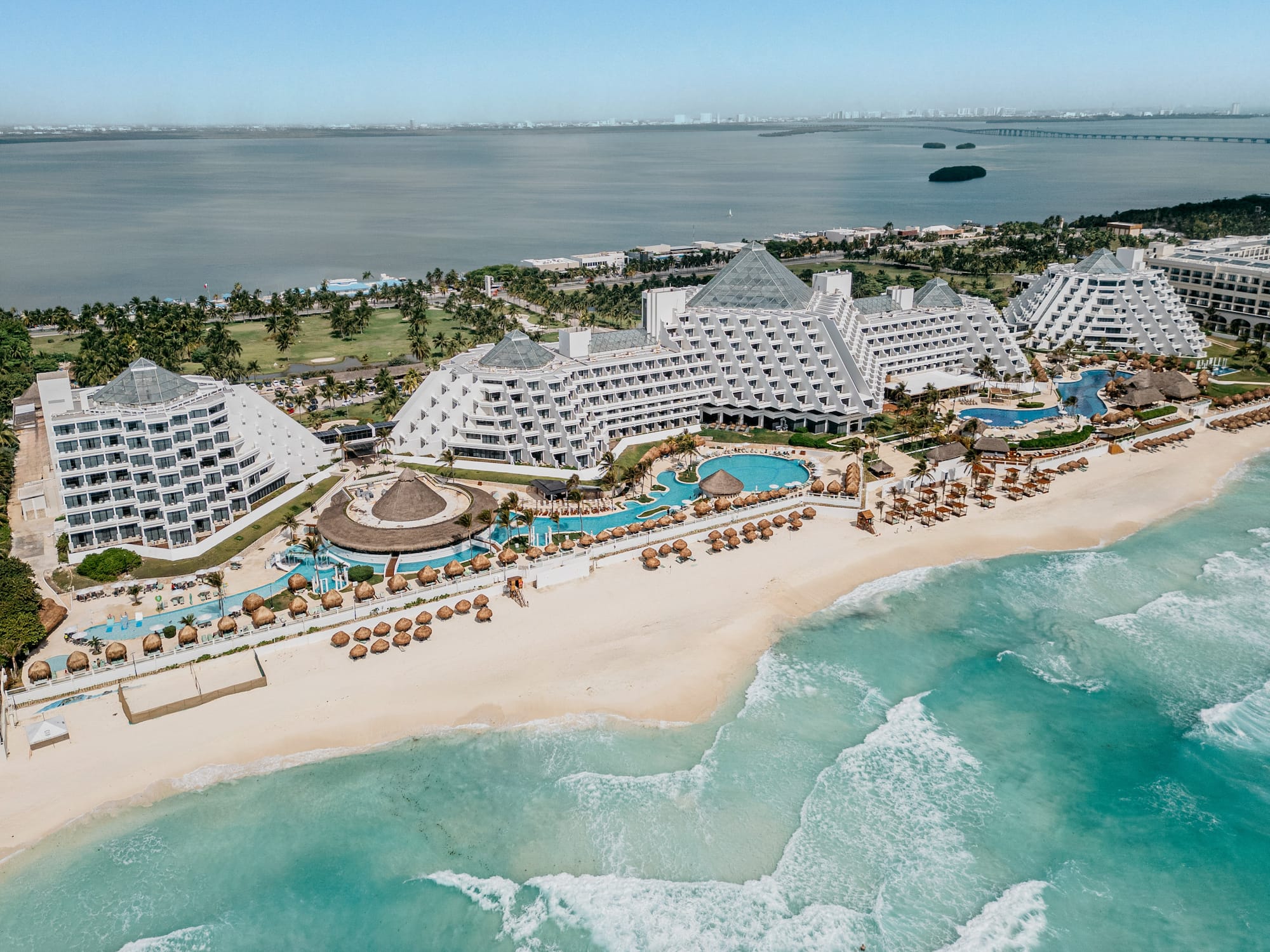 Cancun luxury resort on white sand beach, pyramid hotels, turquoise ocean.