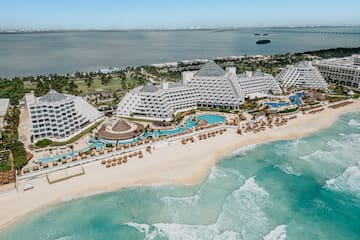 Pyramid resort on a white sand beach with turquoise ocean and pools.