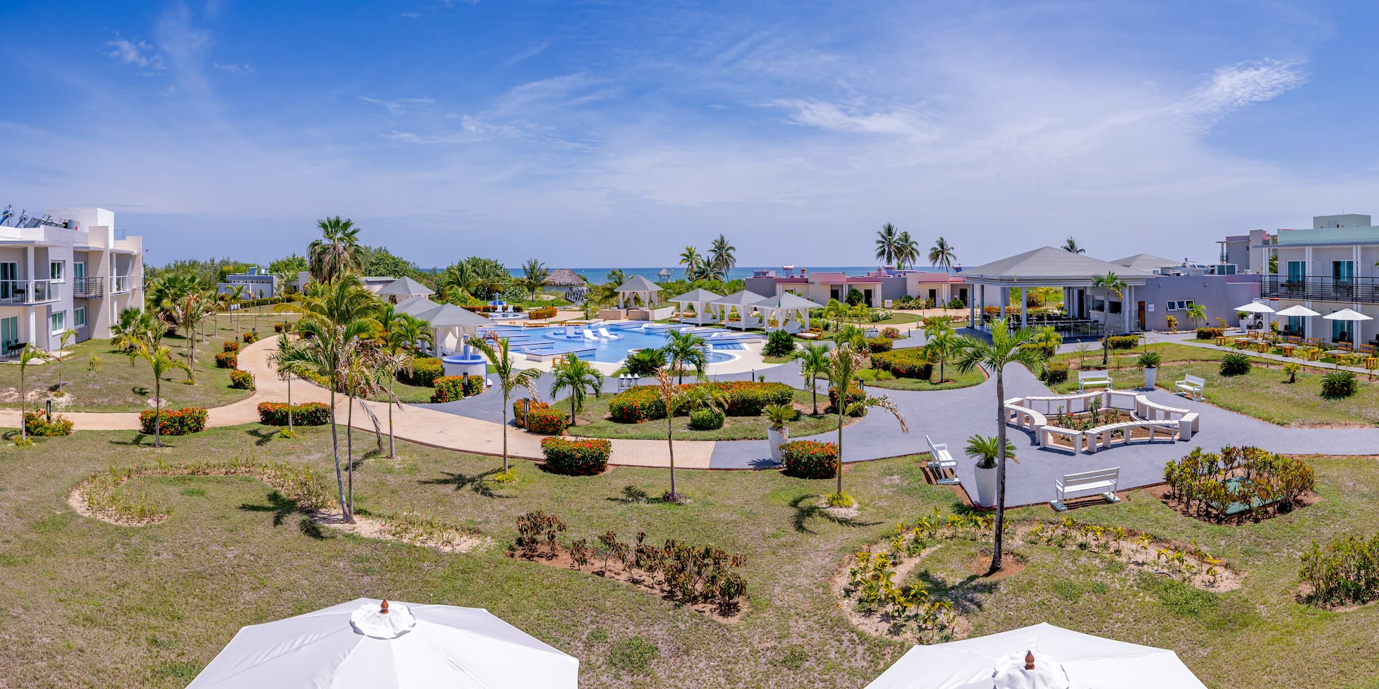 a pool and buildings with umbrellas