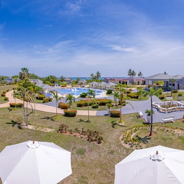 a pool and buildings with umbrellas