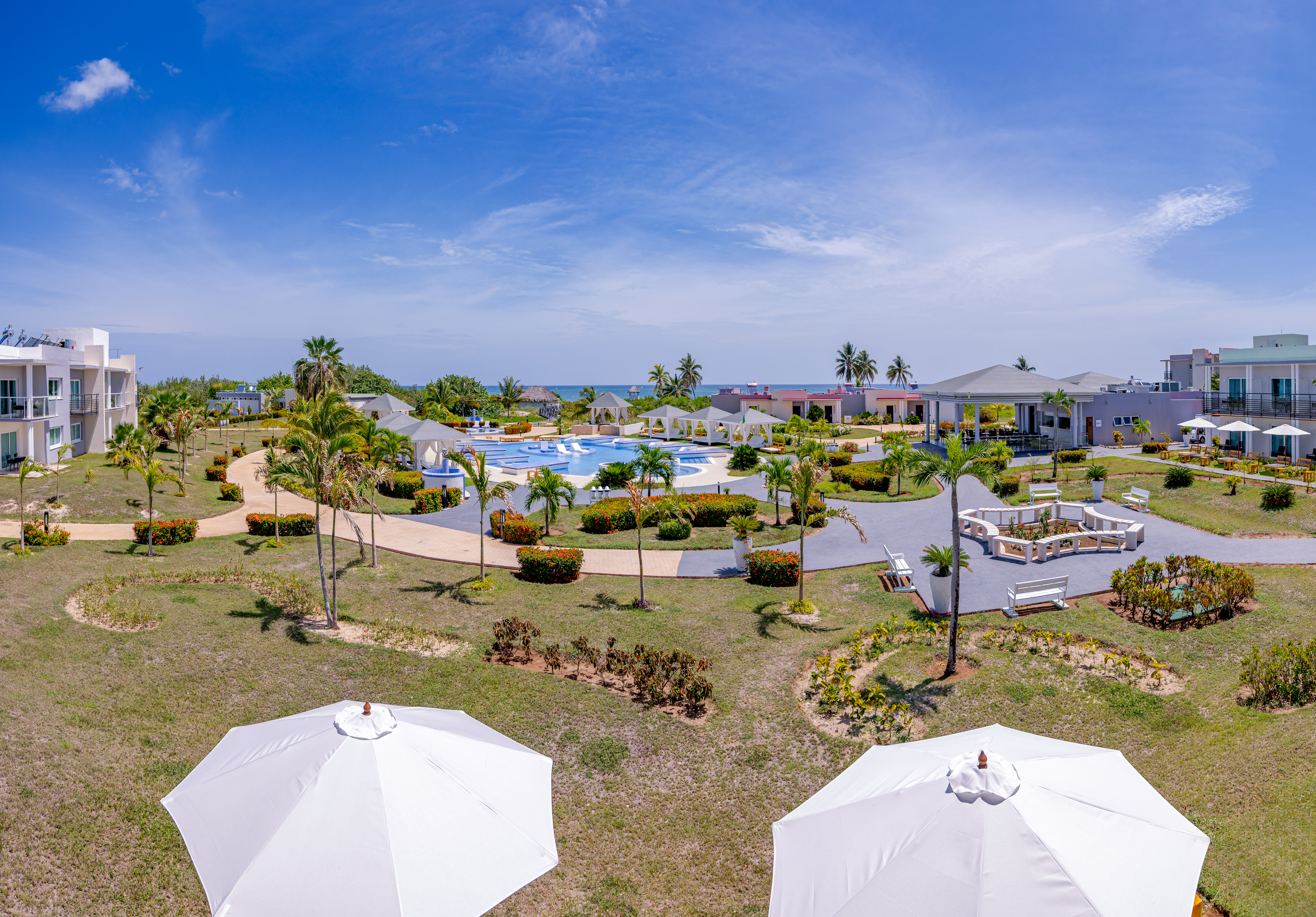 a pool and buildings with umbrellas