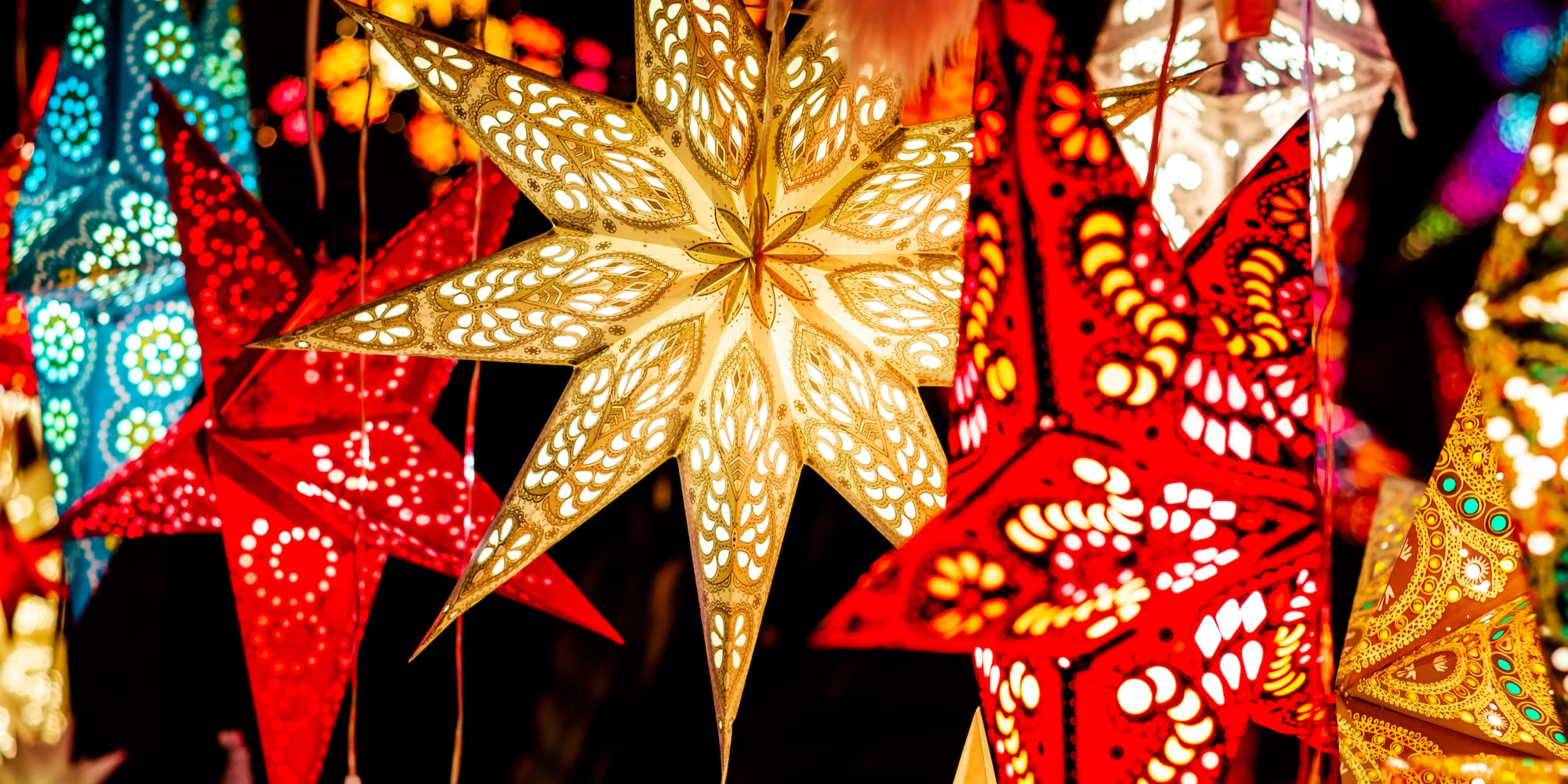 Colorful illuminated star lanterns with intricate patterns, festive decorations.