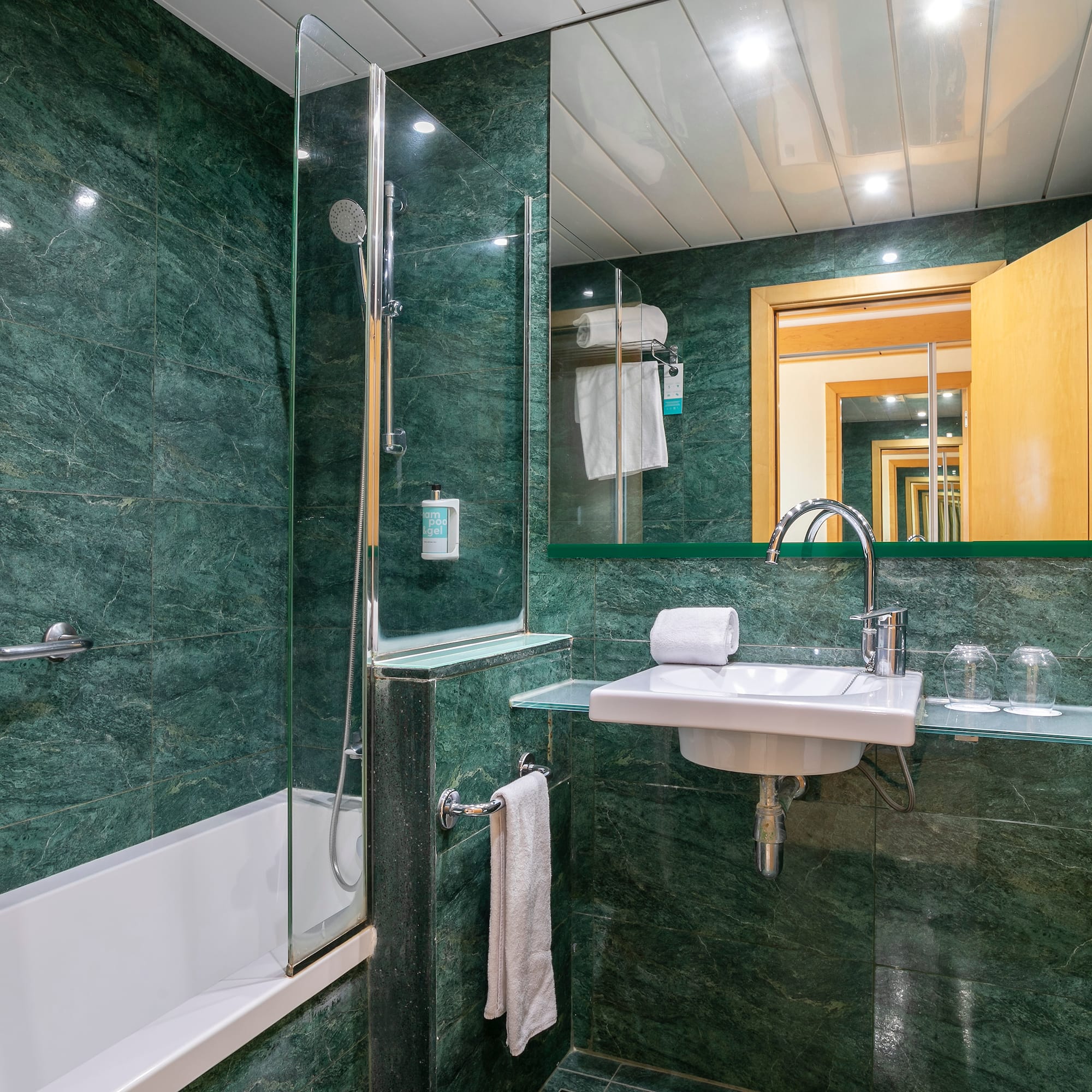 a bathroom with green tiles