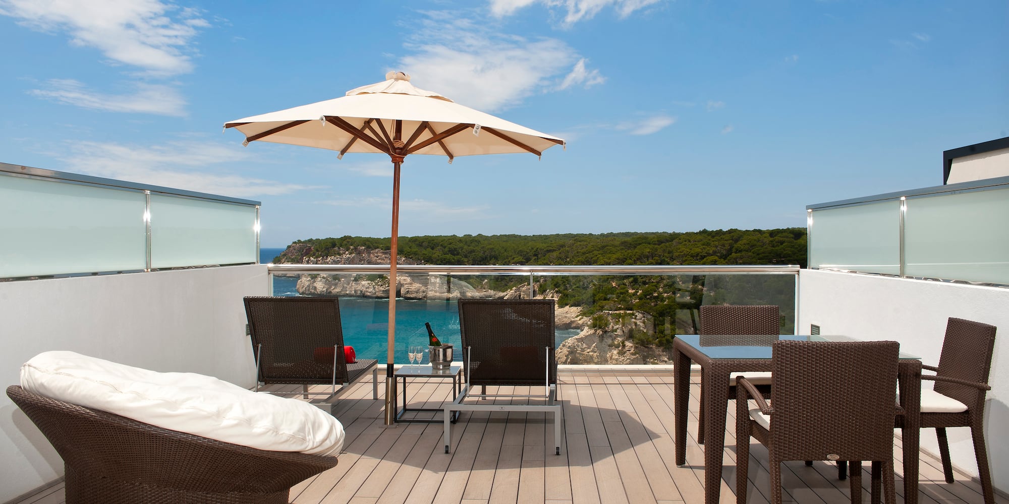a patio with chairs and umbrella on a deck