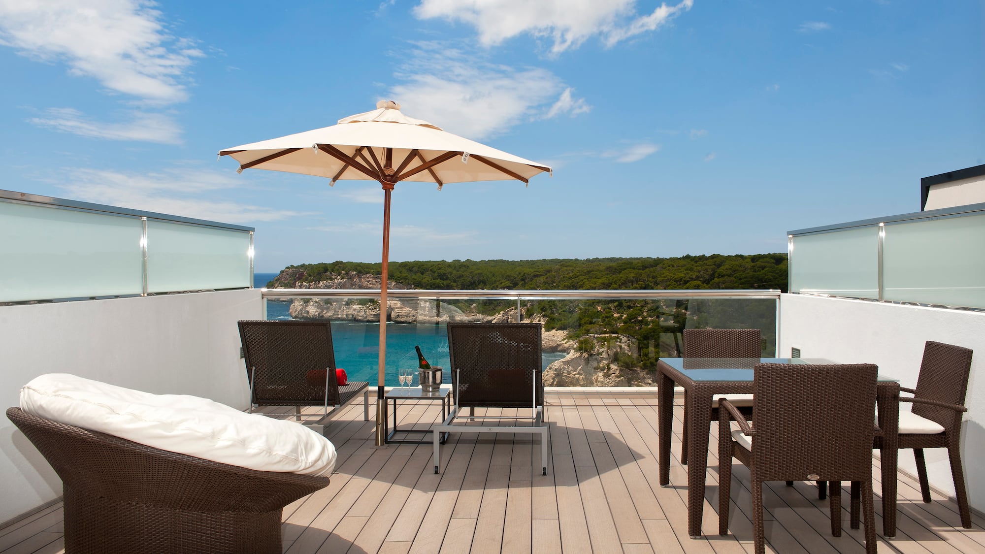 a patio with chairs and umbrella on a deck