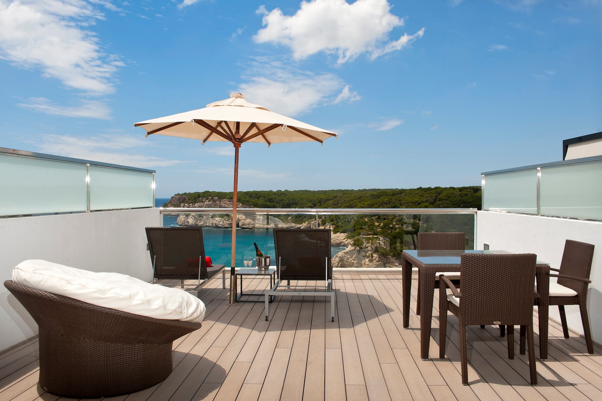 a patio with chairs and umbrella on a deck
