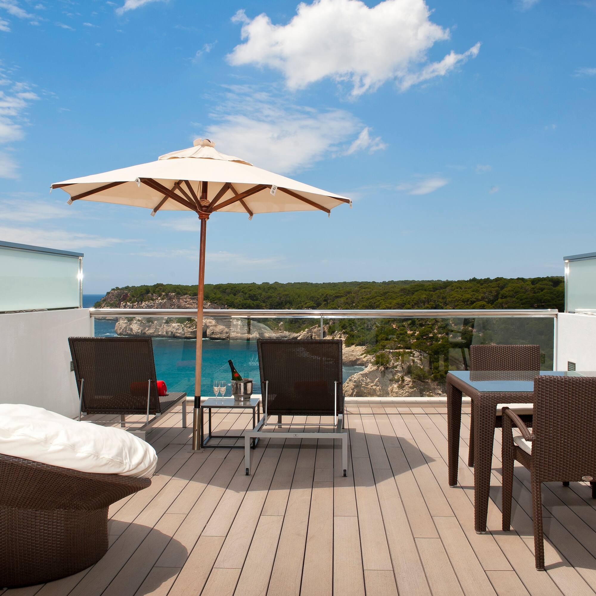 a patio with chairs and umbrella on a deck