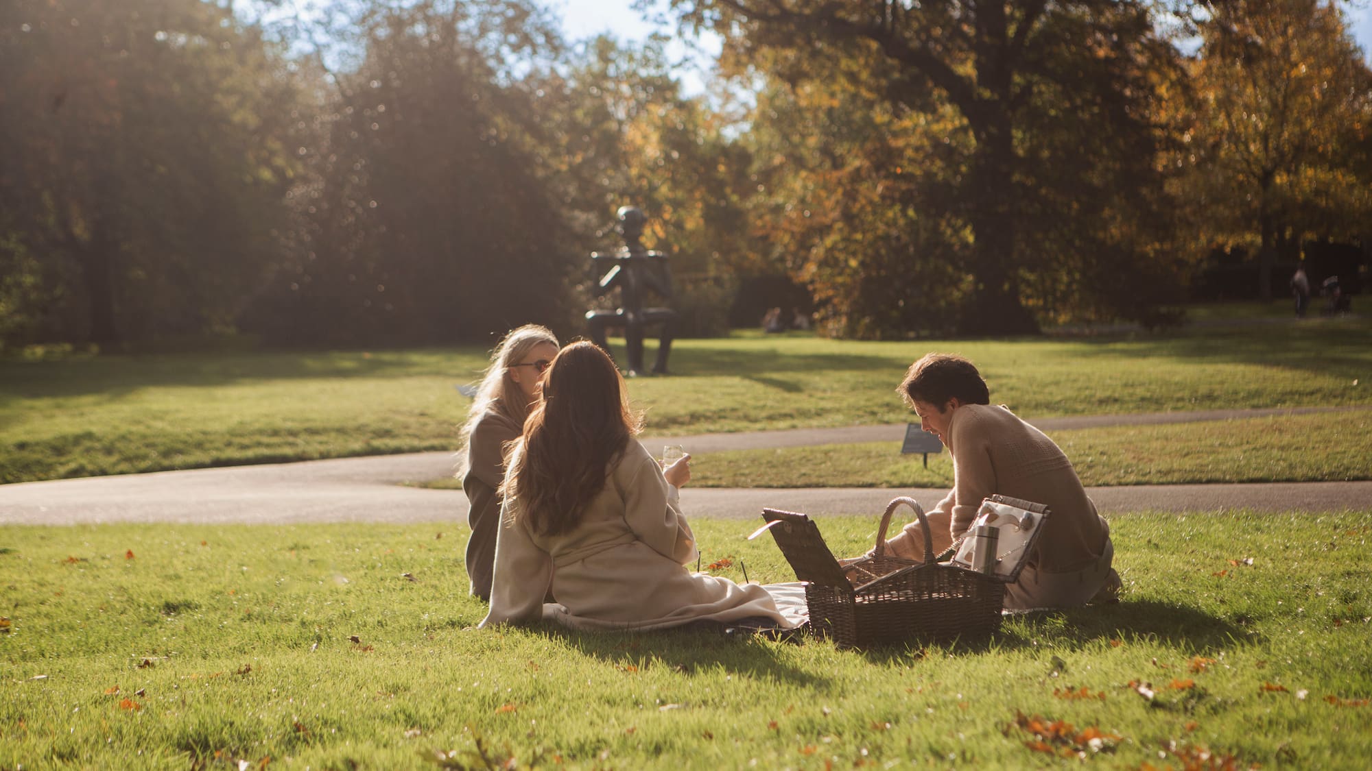 a group of people sitting on grass in a park