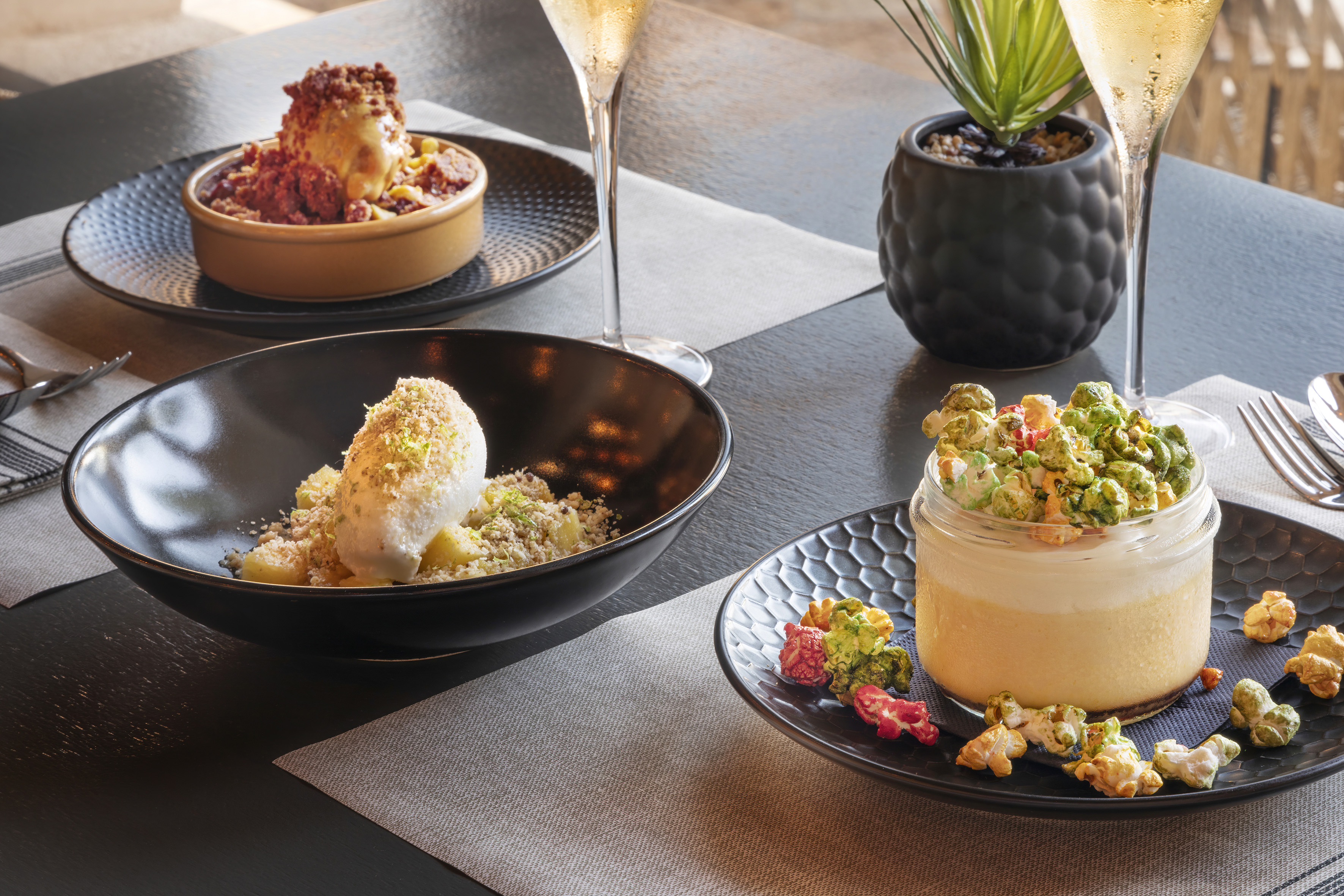 Gourmet desserts: ice cream, fruit crumble, and mousse with colorful popcorn.