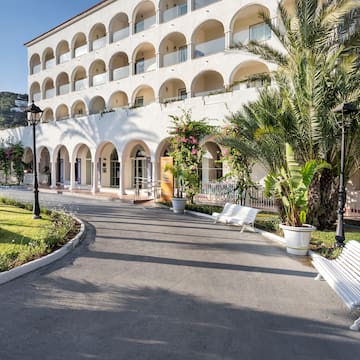 a white building with arches and palm trees