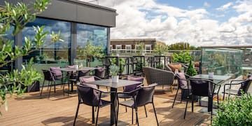 a patio with tables and chairs on a deck