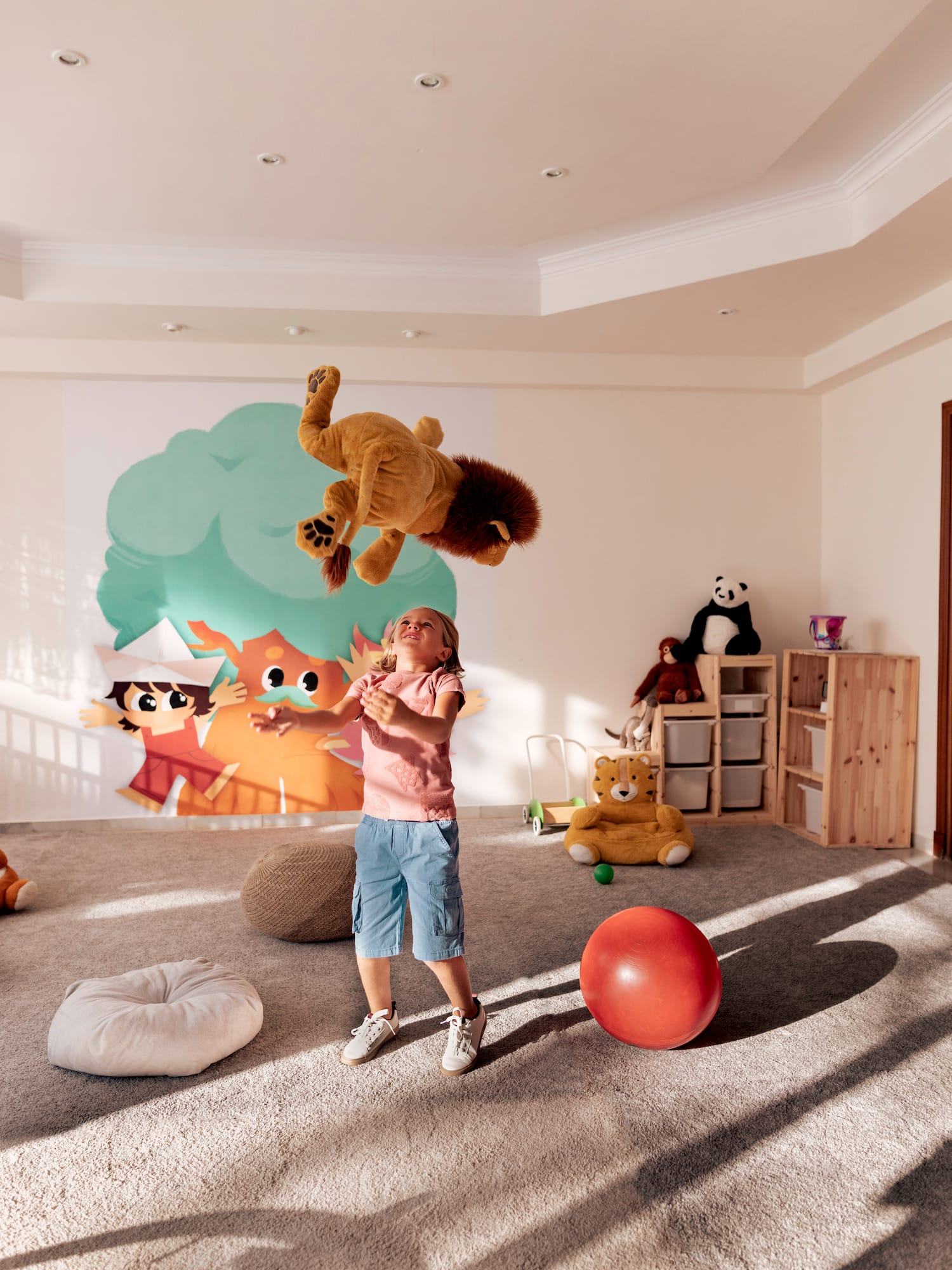 a girl in a room with a stuffed animal