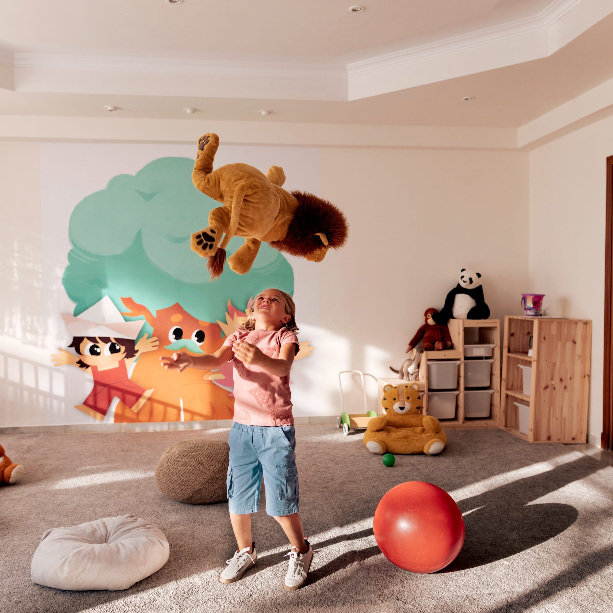 a girl in a room with a stuffed animal