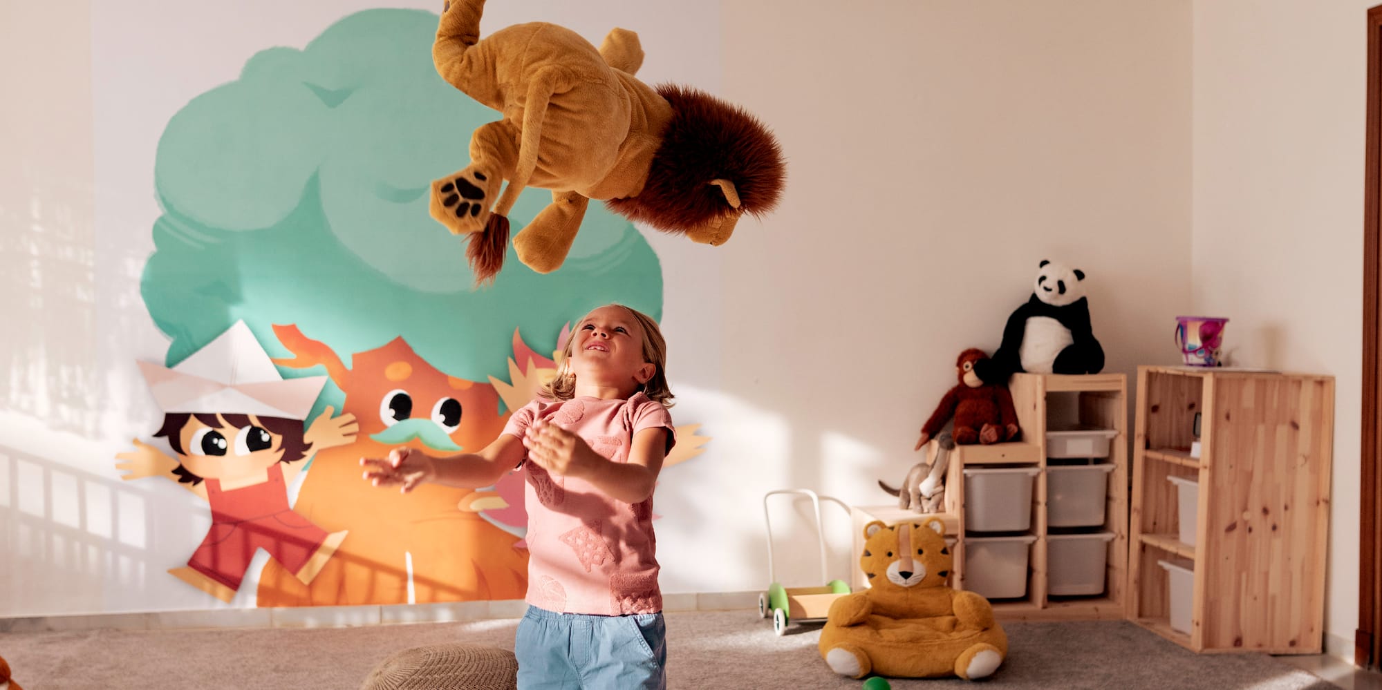 a girl in a room with a stuffed animal