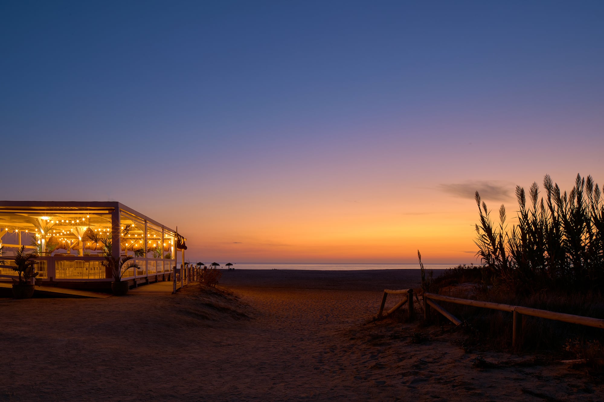 a building with lights on the beach