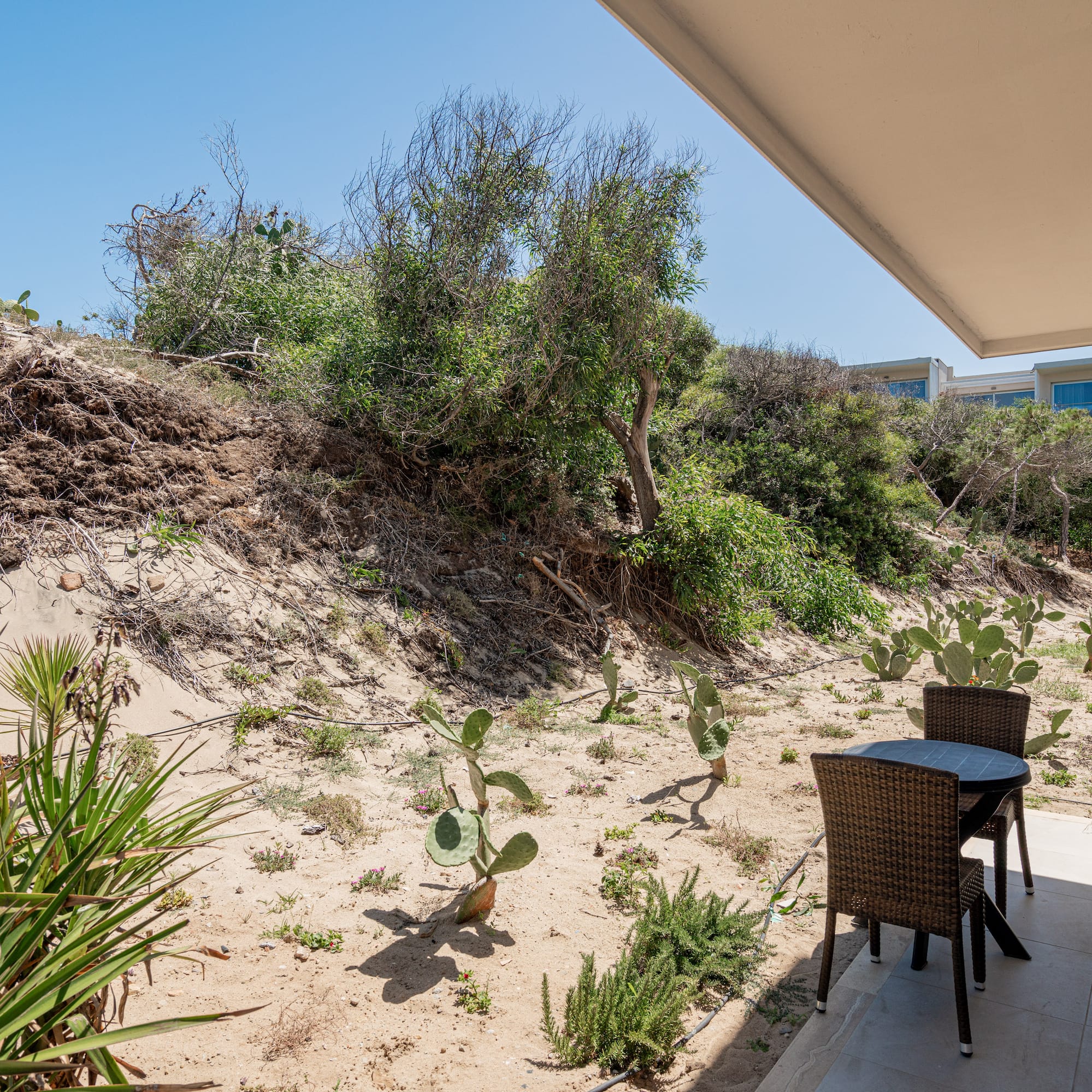 a table and chairs on a patio with a desert landscape