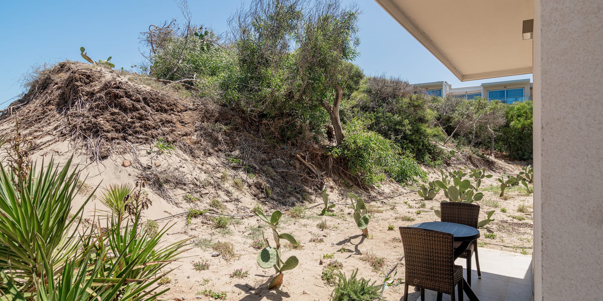 a table and chairs on a patio with a desert landscape