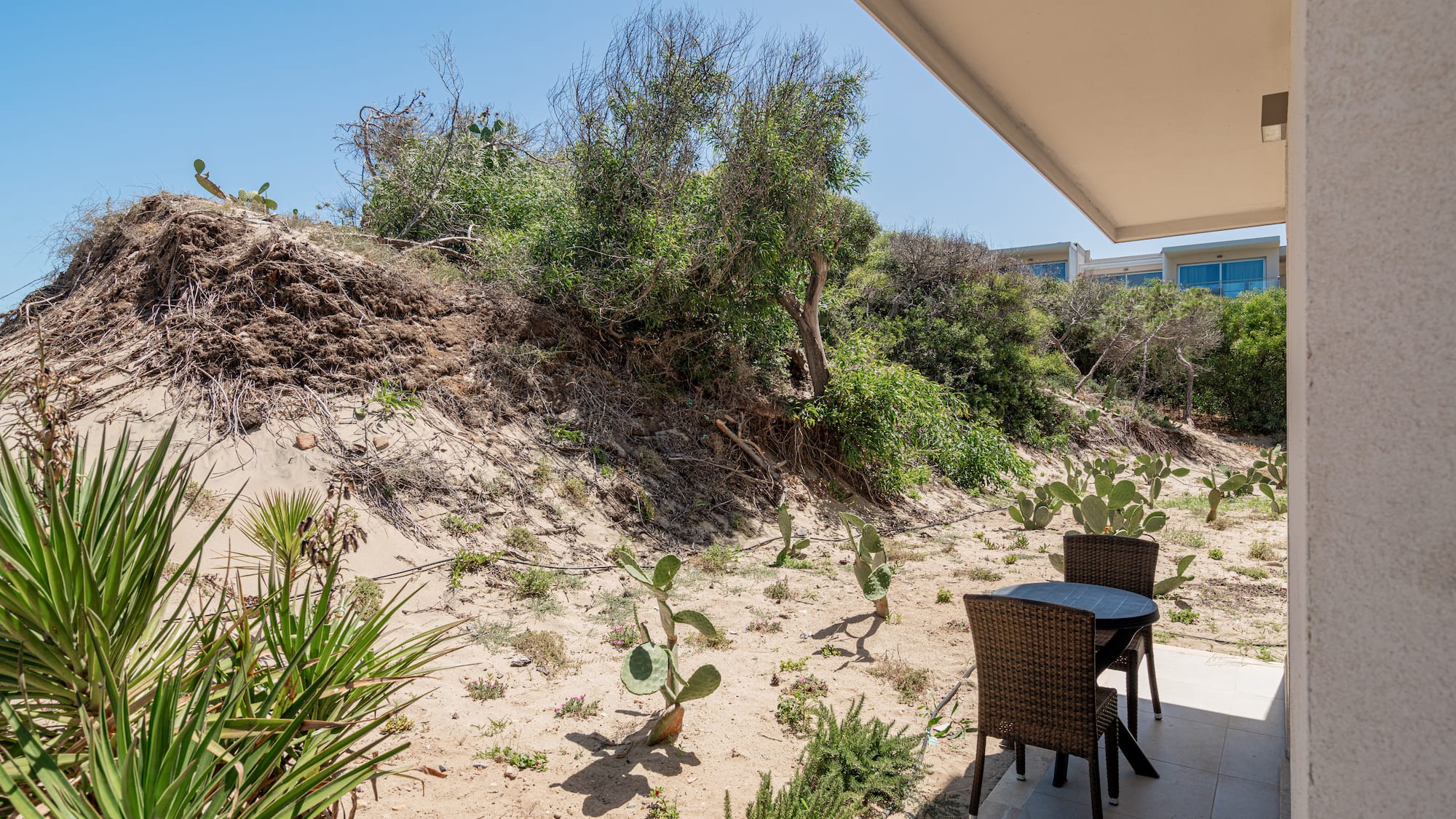 a table and chairs on a patio with a desert landscape