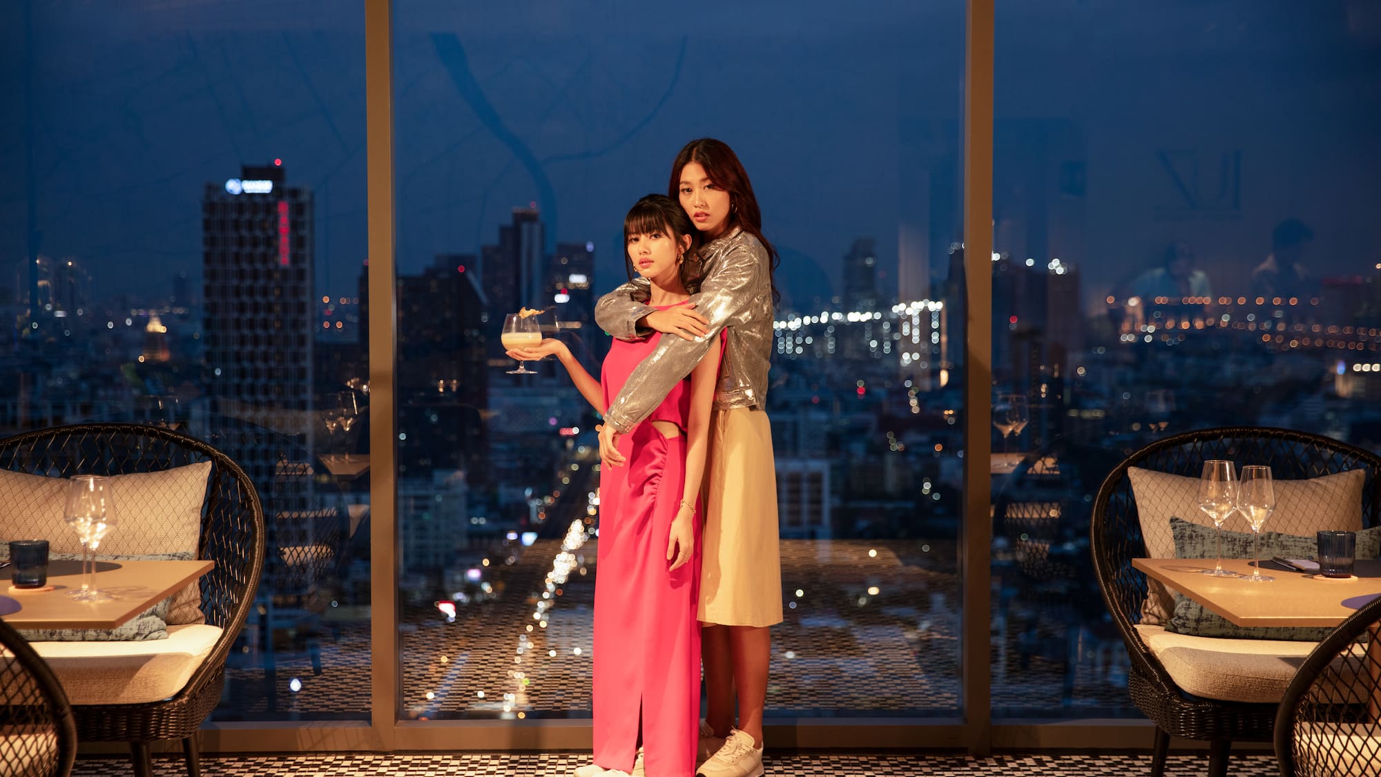 two women standing in front of a window
