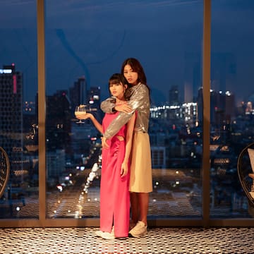 two women standing in front of a window